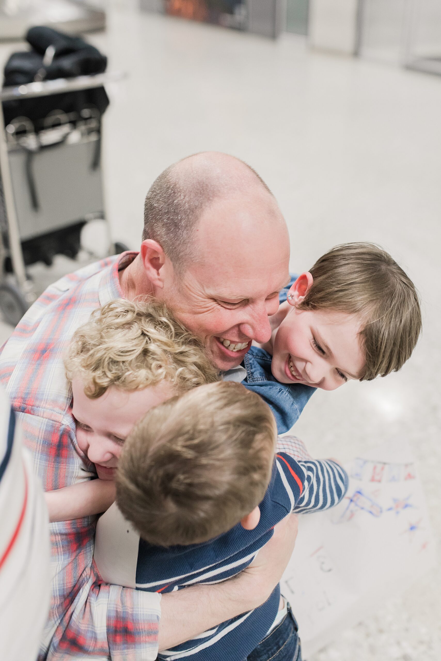 dad hugs kids in airport lobby after military deployment 