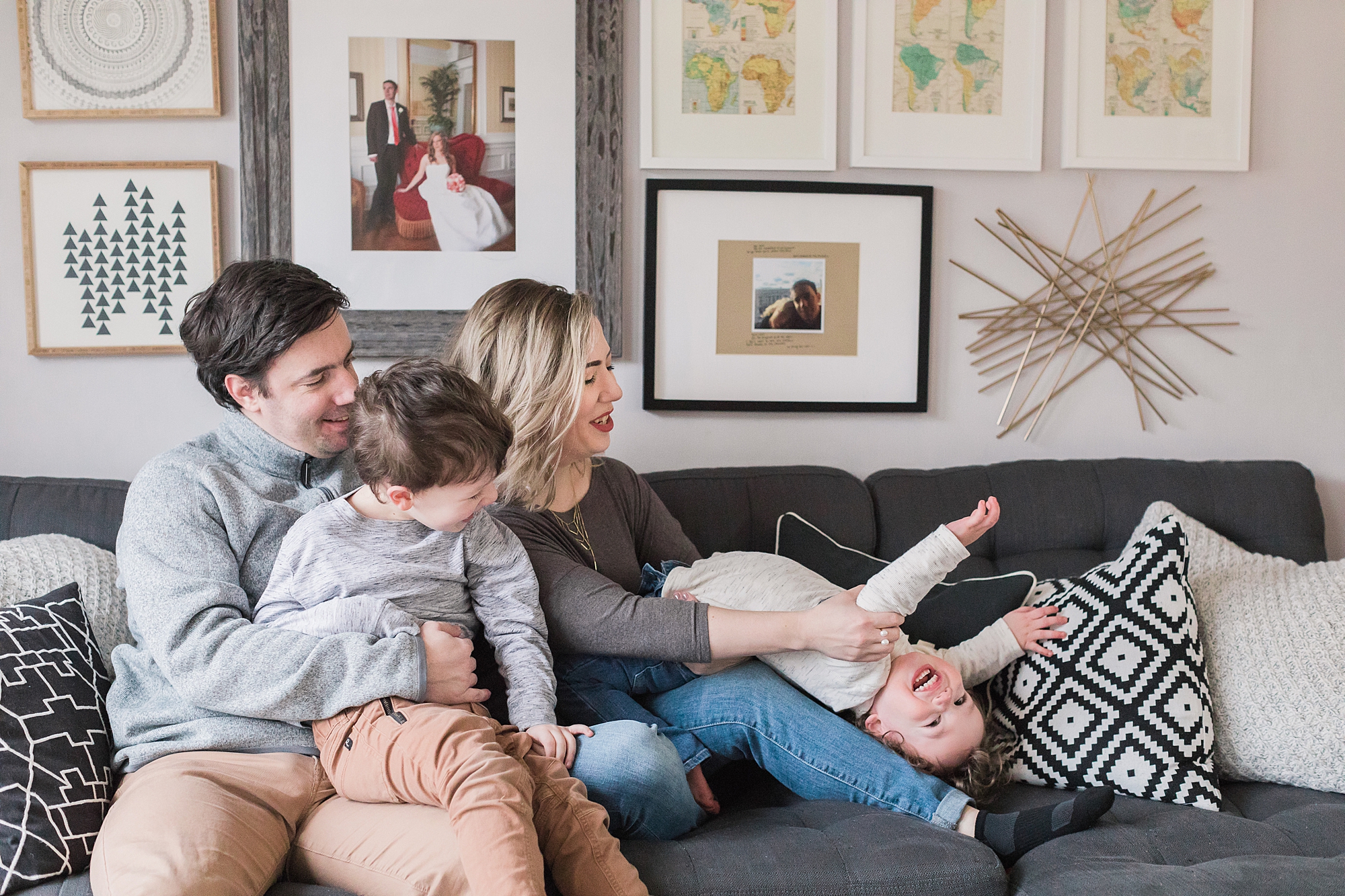 family lays together on couch during lifestyle family photos in Maryland