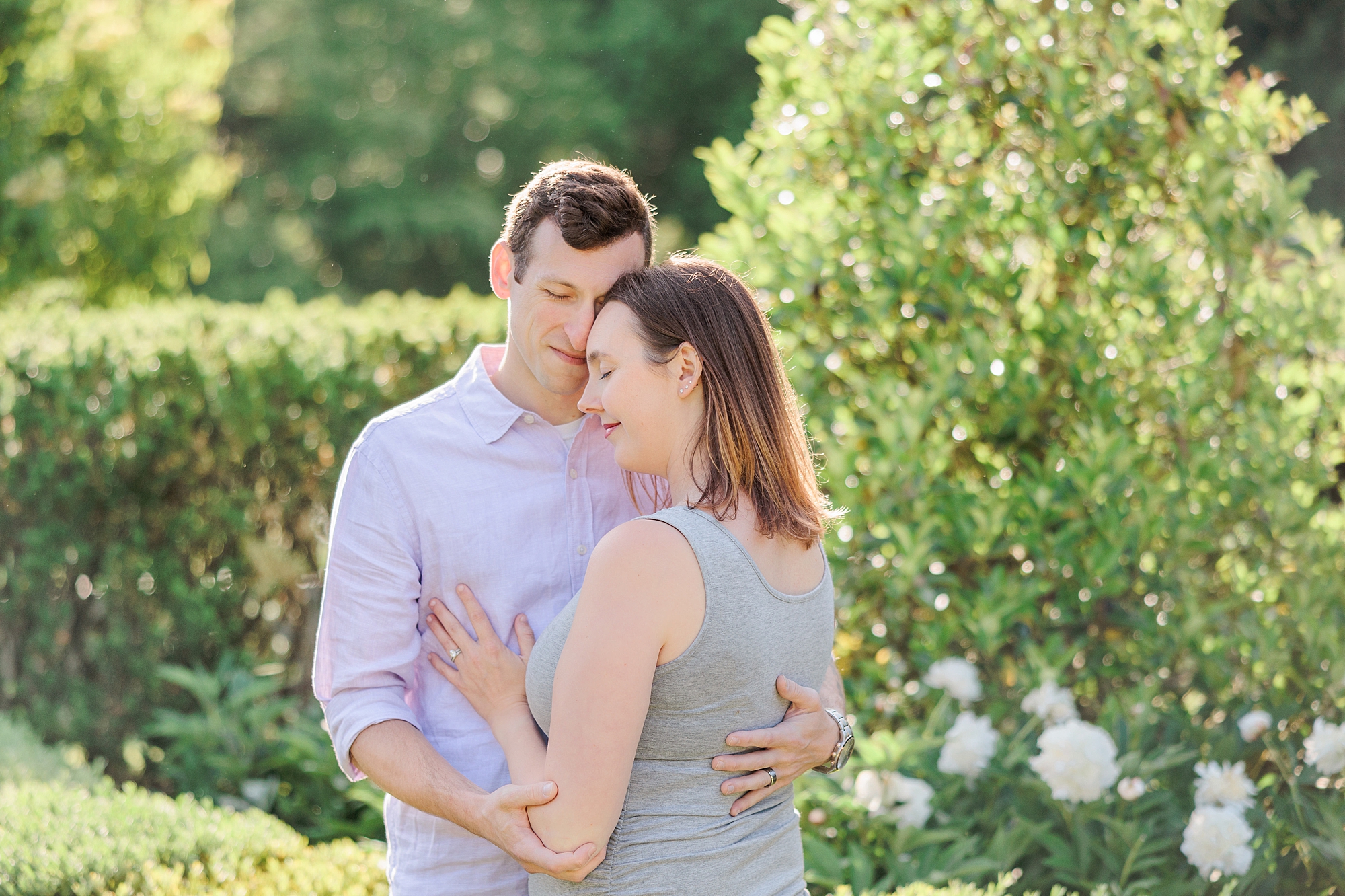 couple hugs in Maryland garden during family photos 