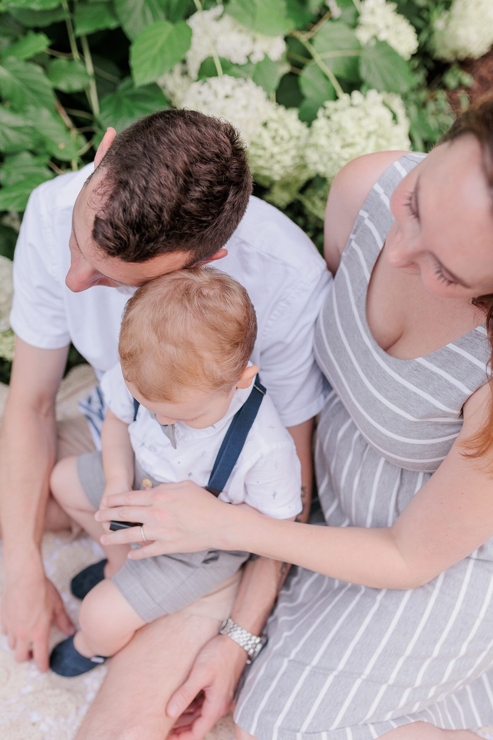 couple sits with son on lap during Maryland maternity session 