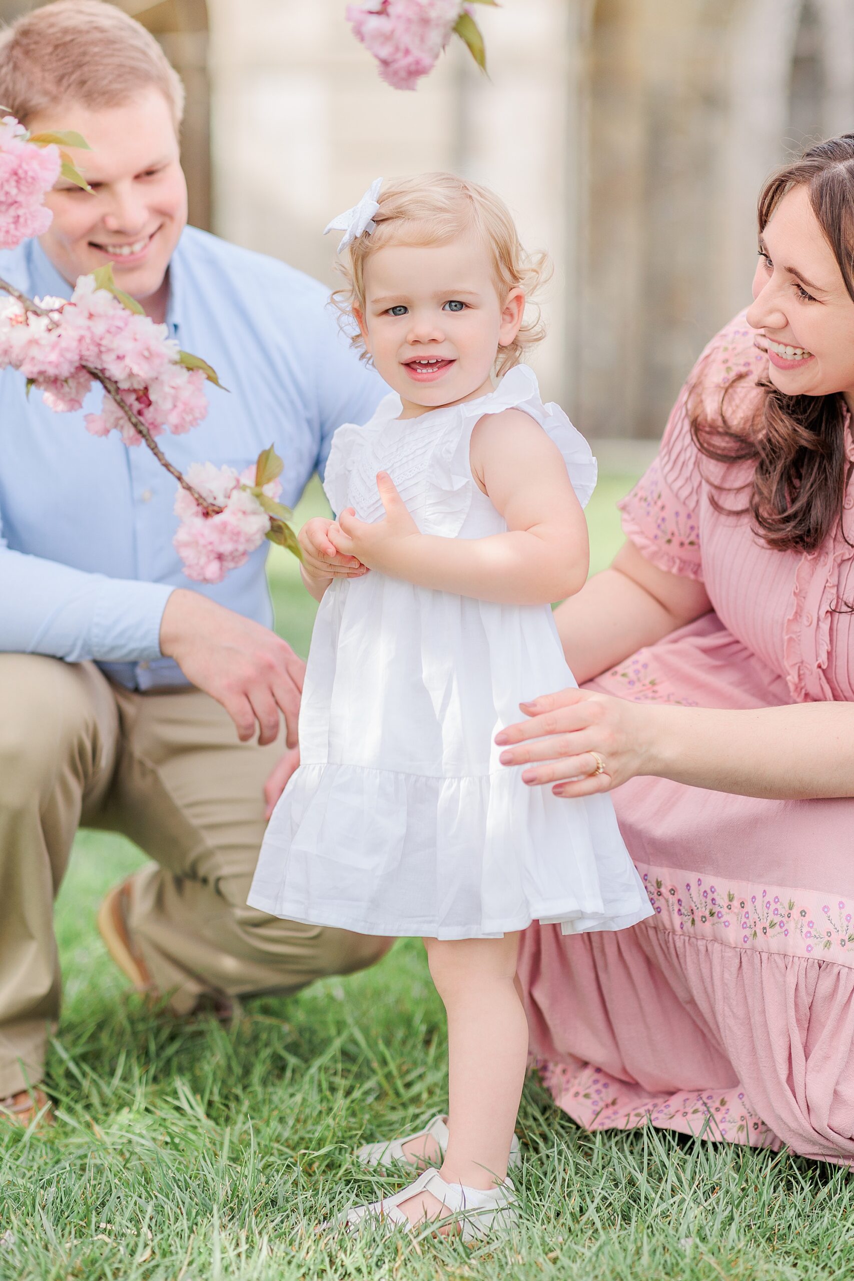 parents look at baby girl in white dress during Howard County spring minis