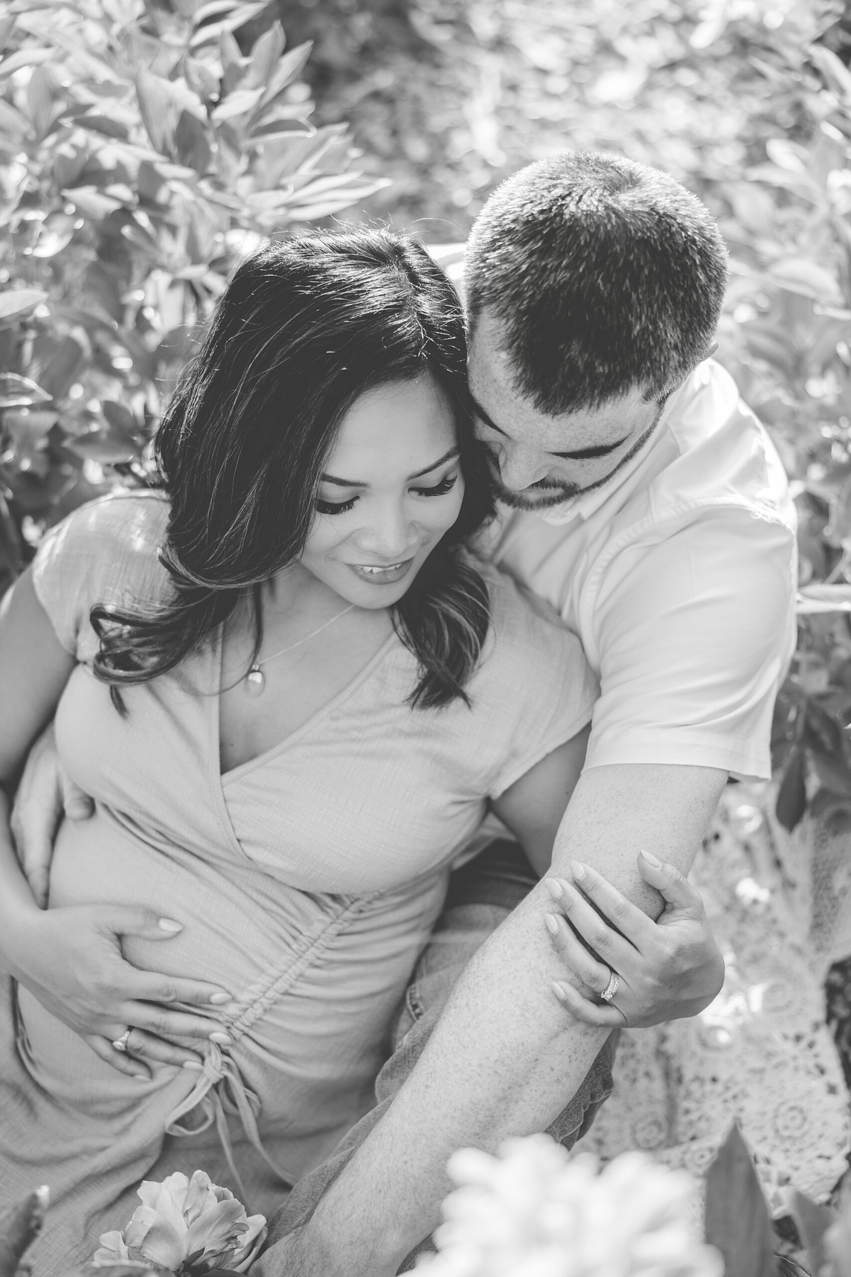 couple hugs in garden during Seneca Creek Park maternity photos