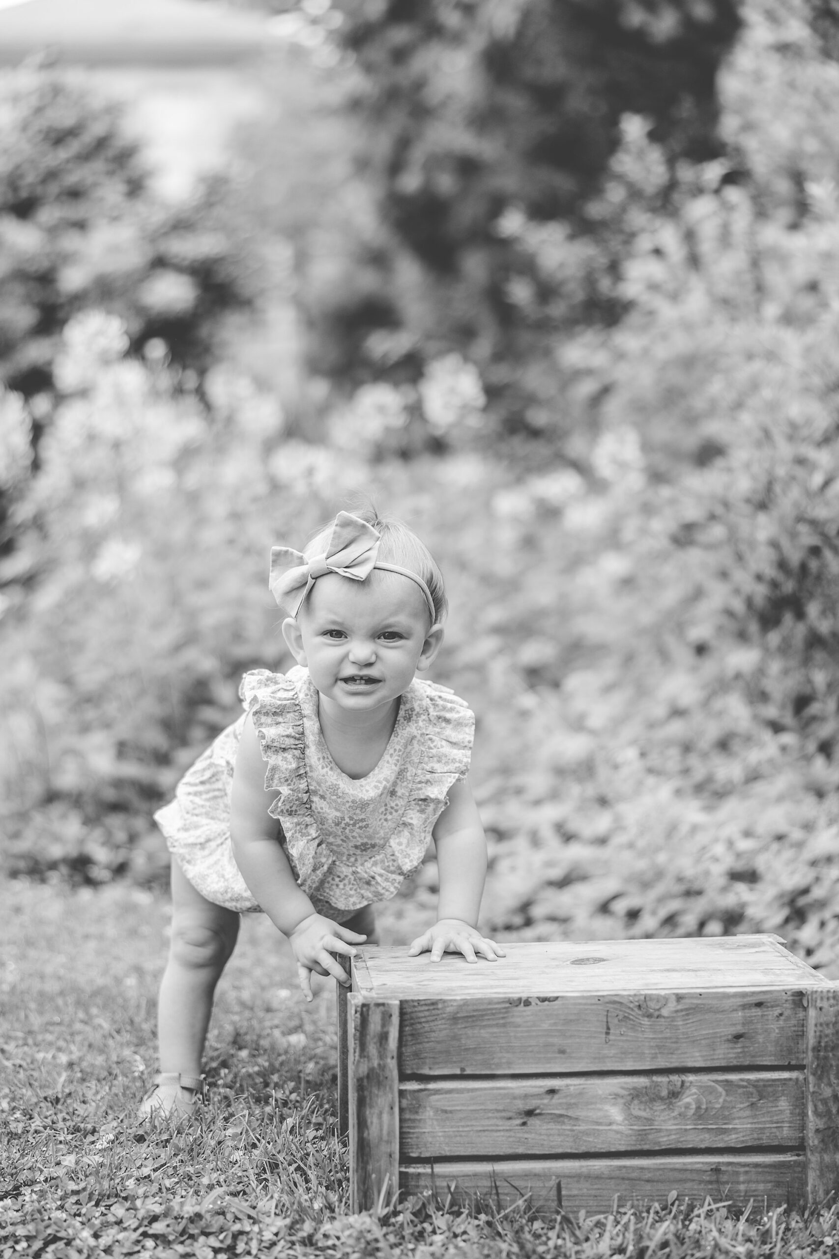 girl plays on wooden crate during family photos in DC