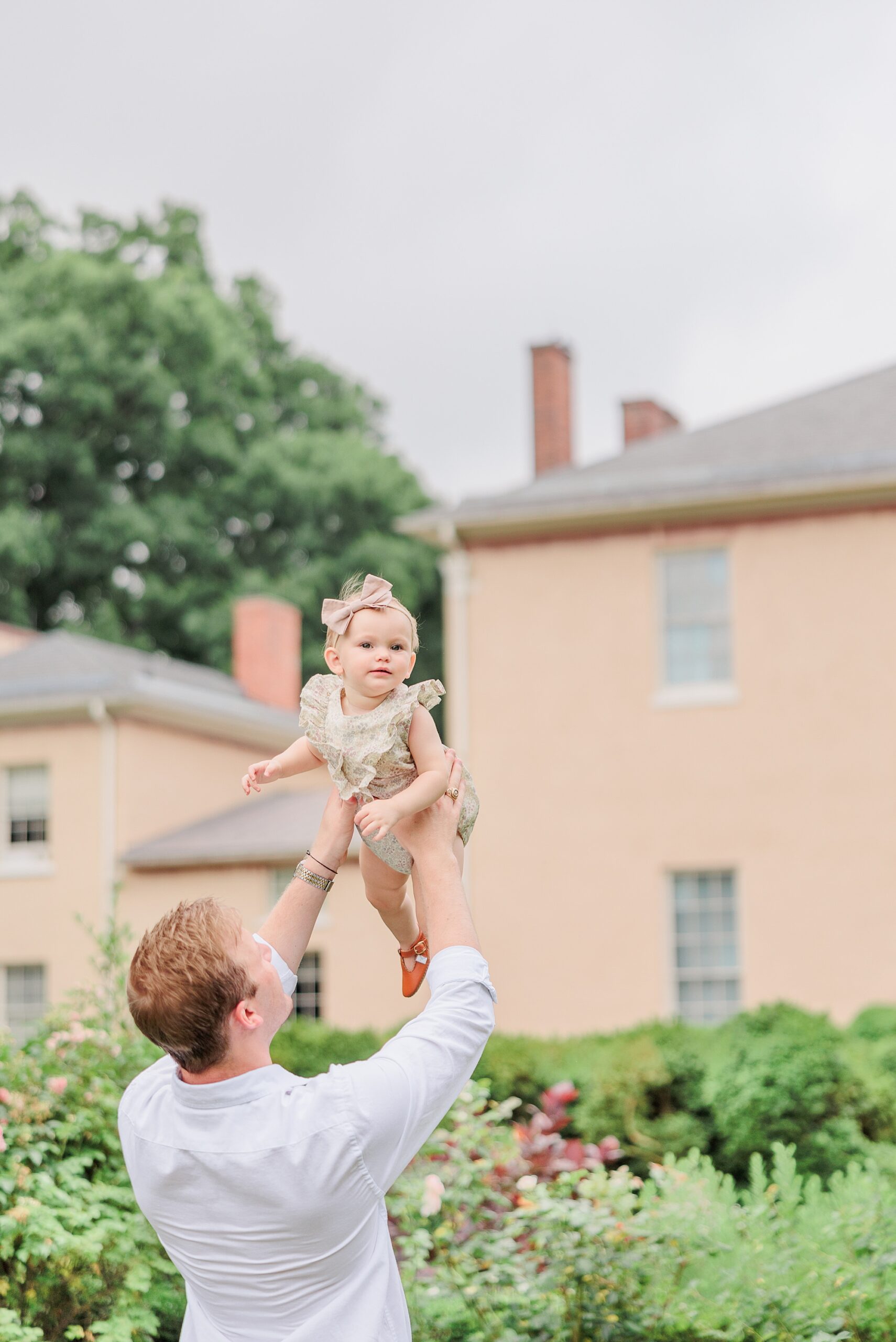 dad tosses daughter in the air during family photos in Washington DC