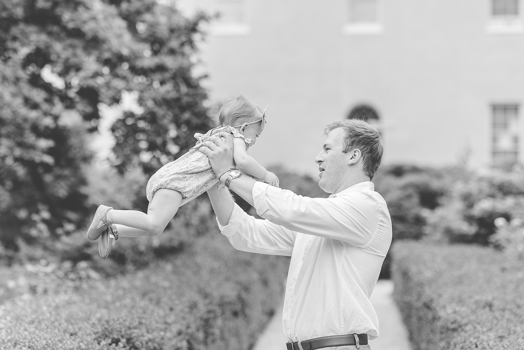 dad plays with daughter on driveway during Tudor Place family photos