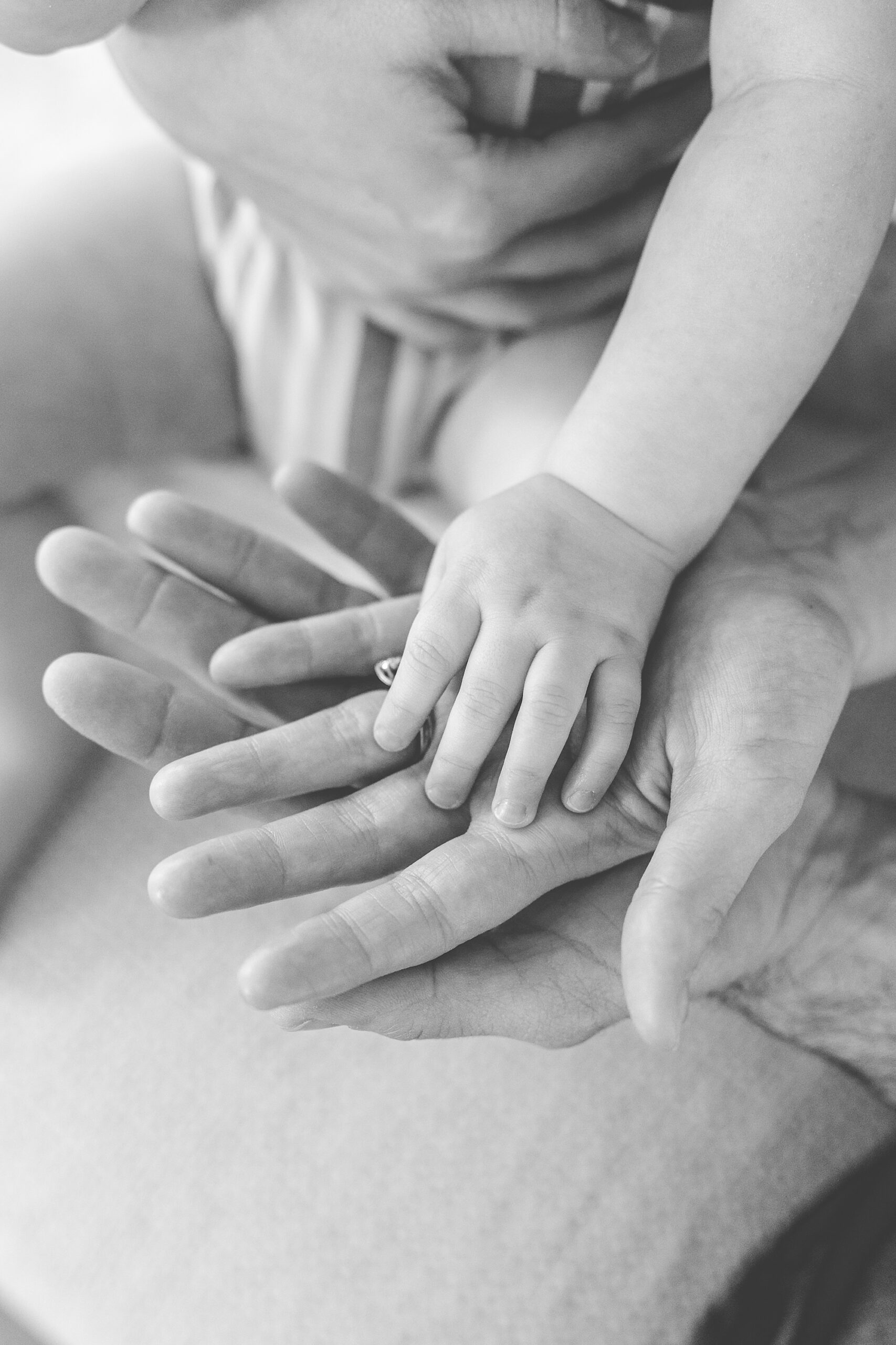 baby places hands on mom and dad's hands