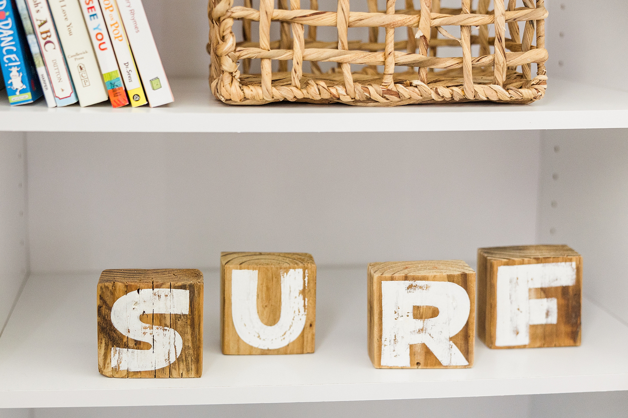 wooden blocks that say SURF on nursery shelf