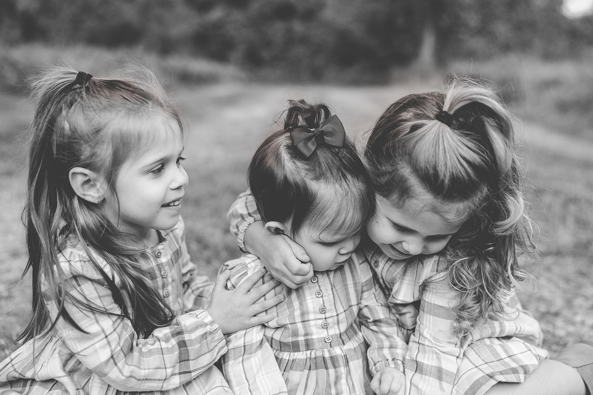 girls hug little sister between them during family photos in Northern VA