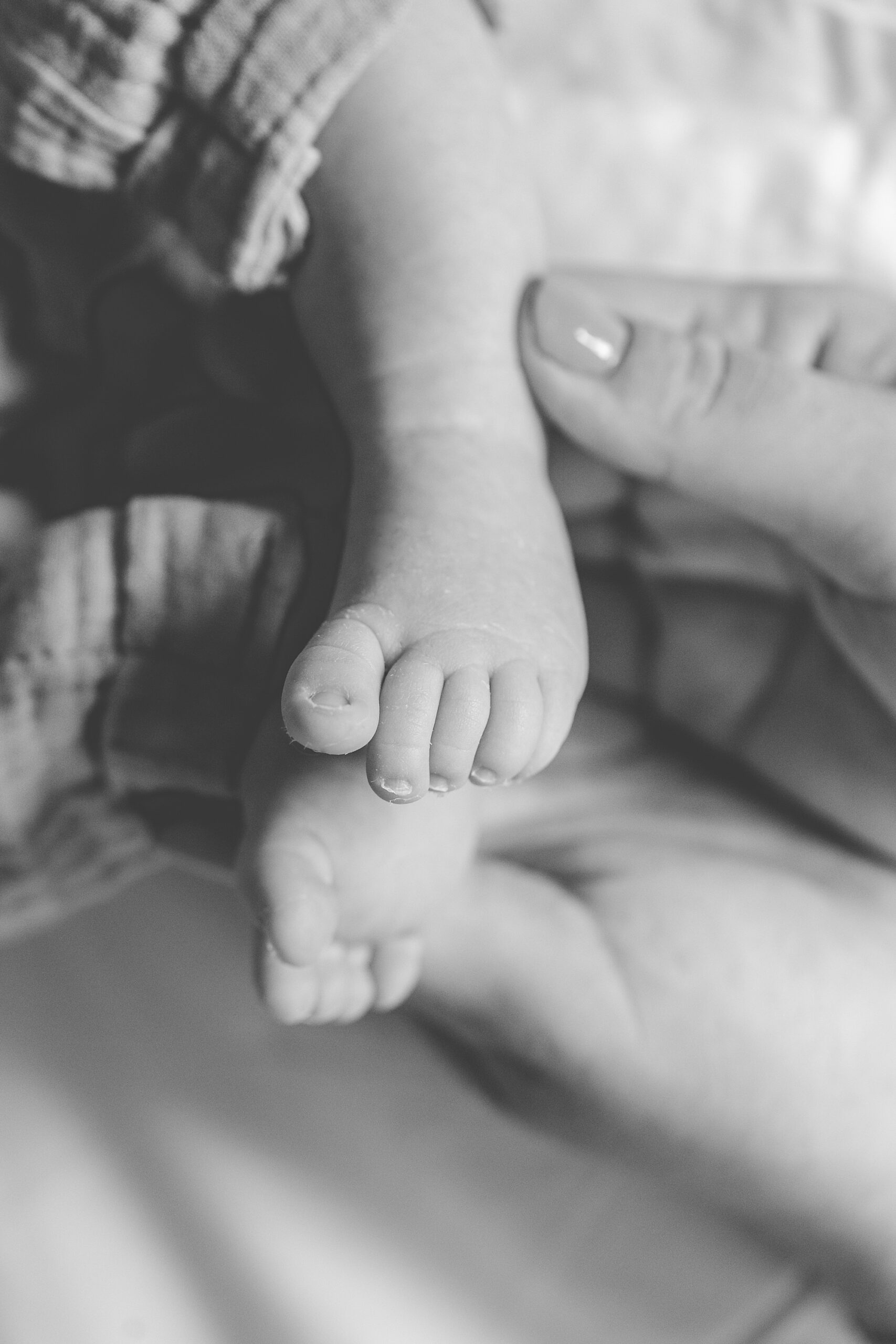toddler and newborn feet together on bed