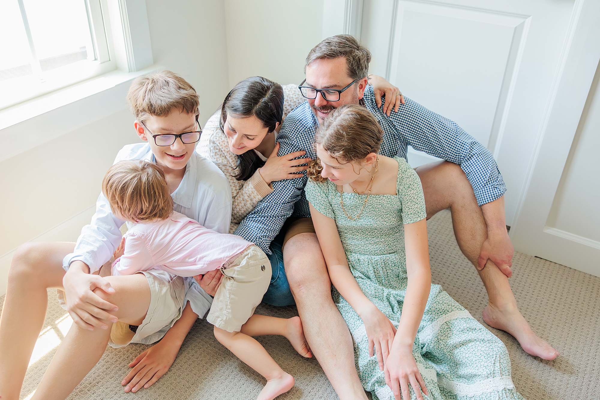 family sits together during family photos - tips for why you need a longer photo session with MD family photographer