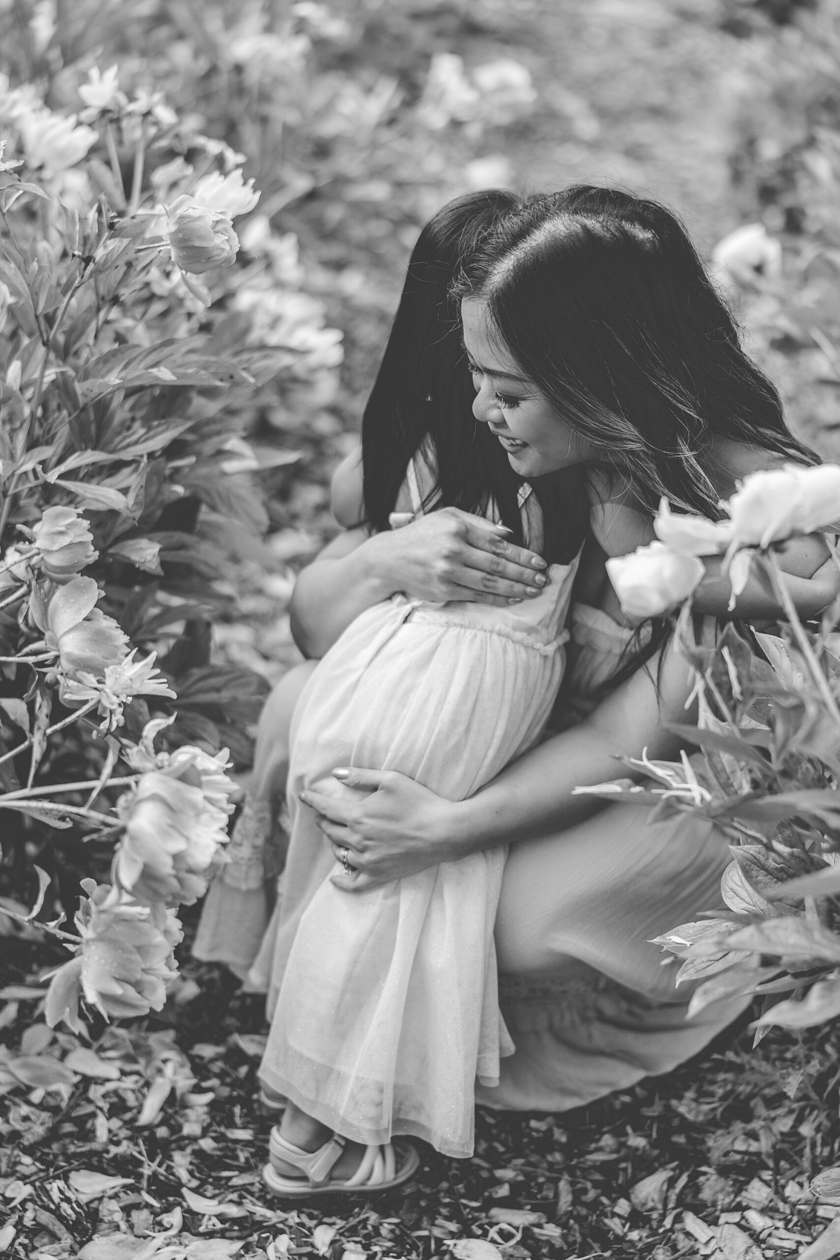woman hugs daughter during mommy & me photos in peonies