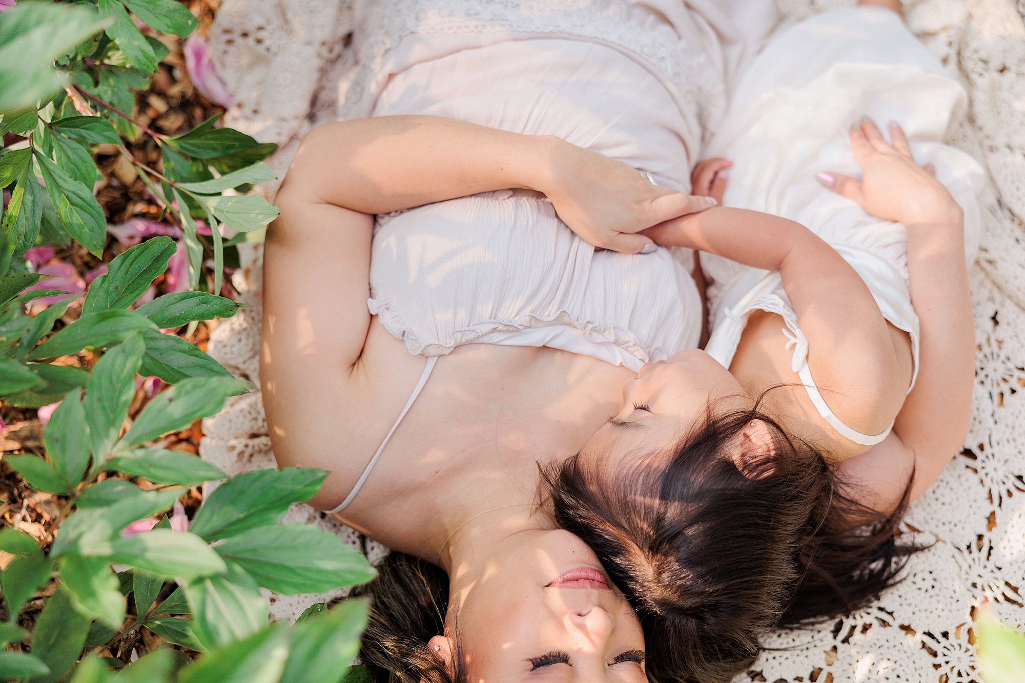 mom and daughter lay together during mommy & me photos in Gaithersburg garden