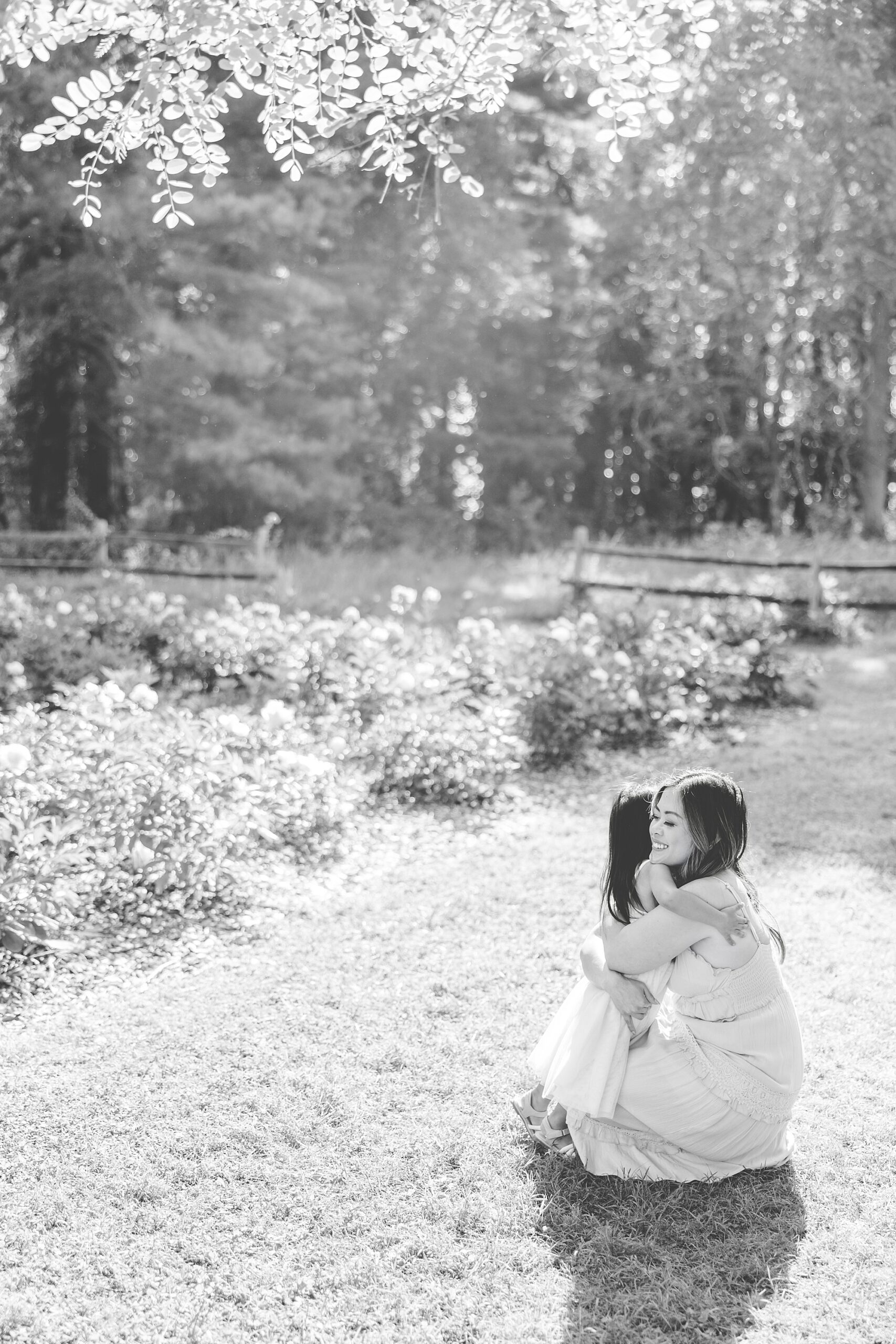 woman hugs daughter during Maryland family photos in peonies 