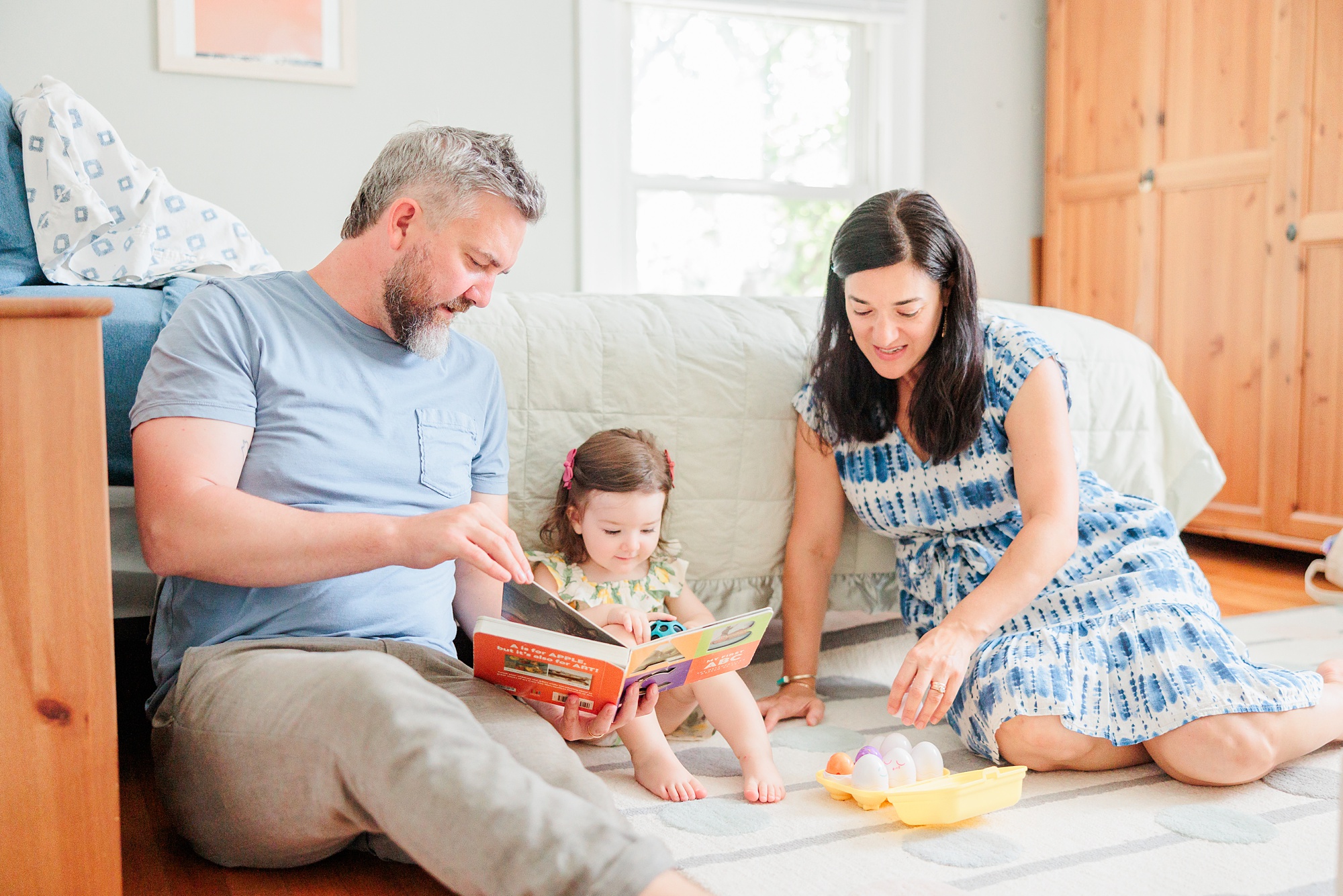 parents read with toddler on bed during MD family photos at home