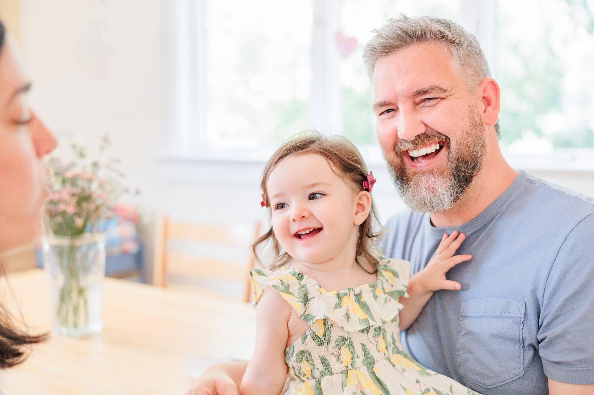 dad and daughter laugh together sitting on table
