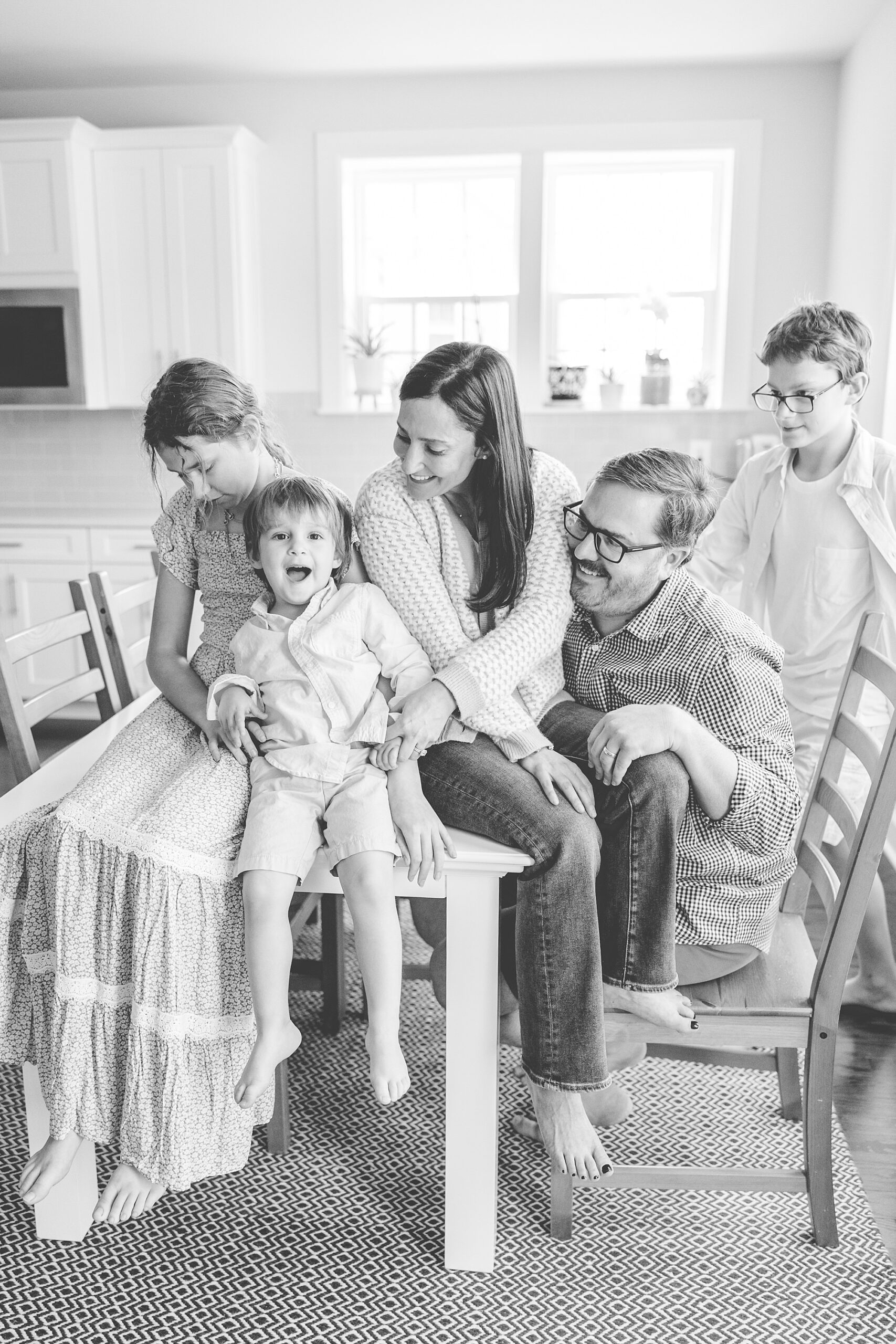 family sits together on chair in kitchen during Maryland lifestyle family photos