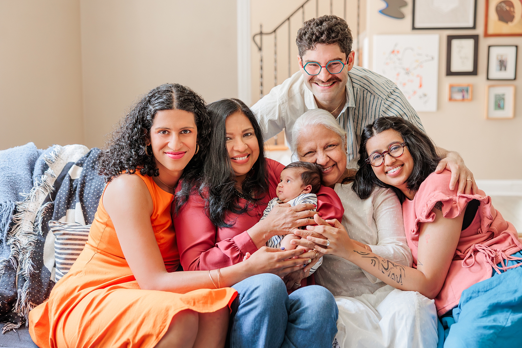 generational newborn portraits in Silver Spring MD home while three women hug new baby and couple 