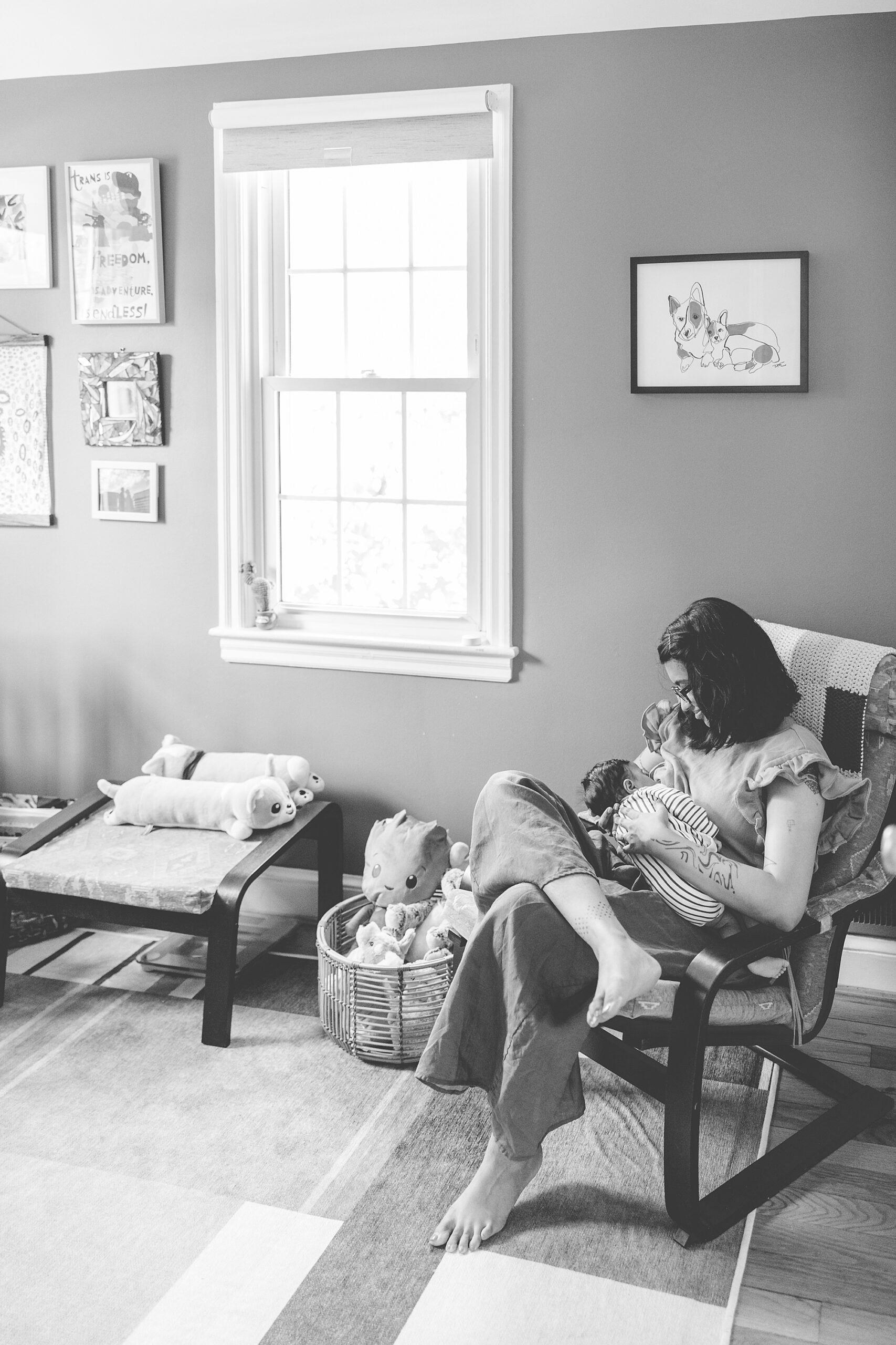 woman holds baby in rocker during lifestyle newborn portraits in Silver Spring MD