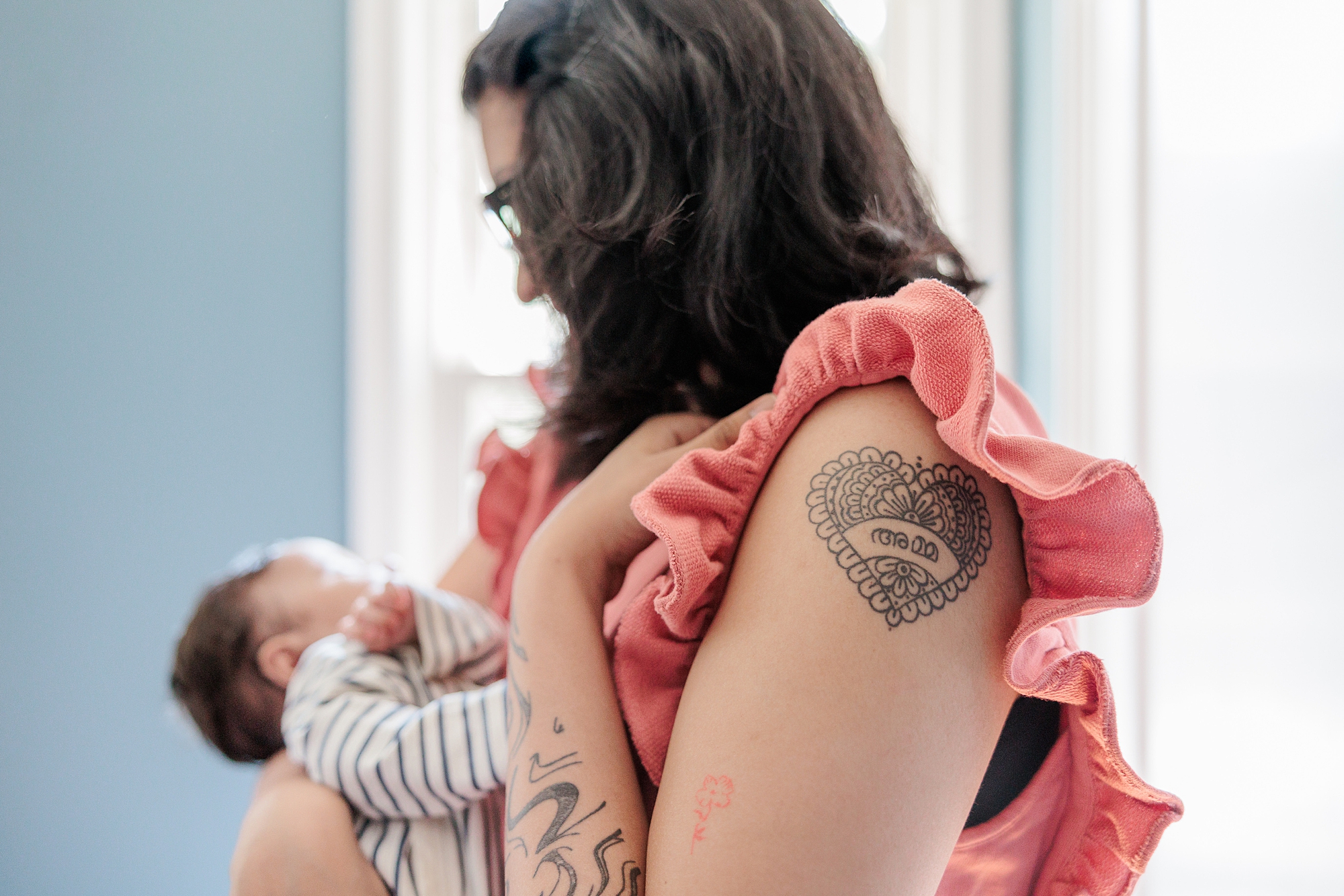 mom holds daughter while showing off motherhood tattoo 