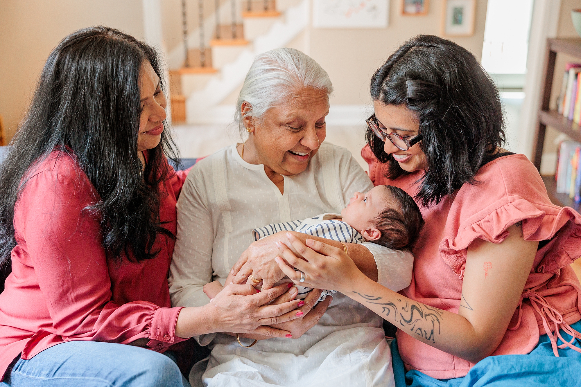 woman sits on couch with daughter, mother, and grandmother during generational lifestyle newborn portraits in Silver Spring MD