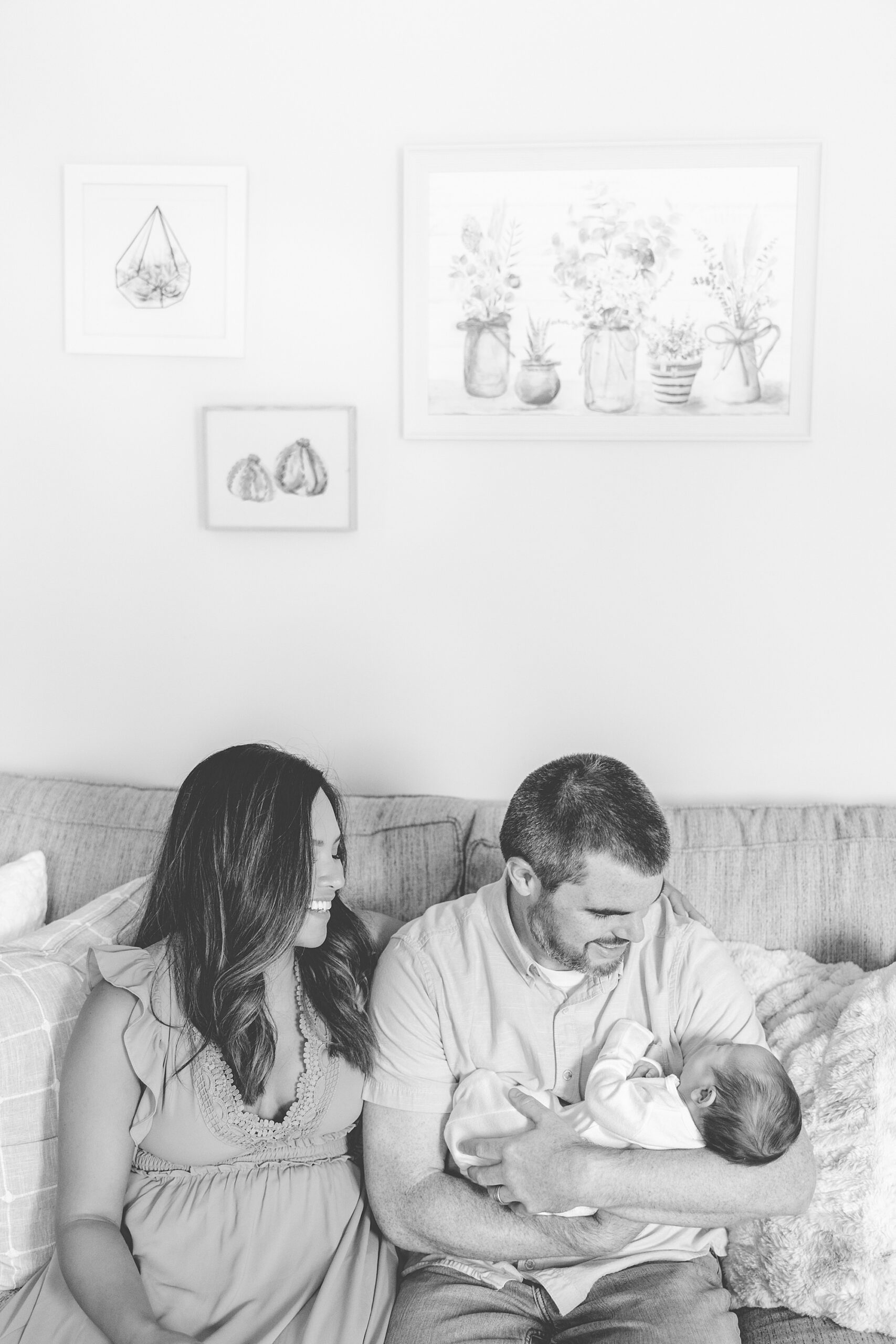 parents look down at newborn son during lifestyle photos at home