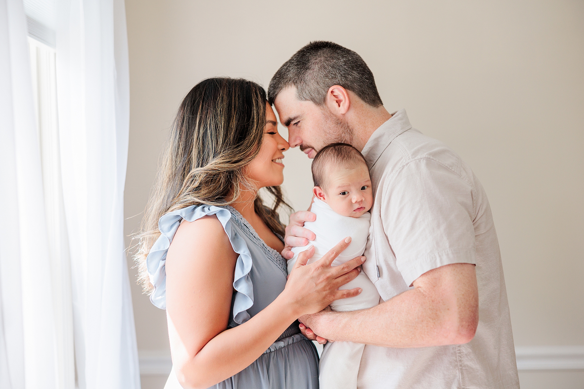 dad holds son leaning to kiss mom during Northern Virginia newborn session