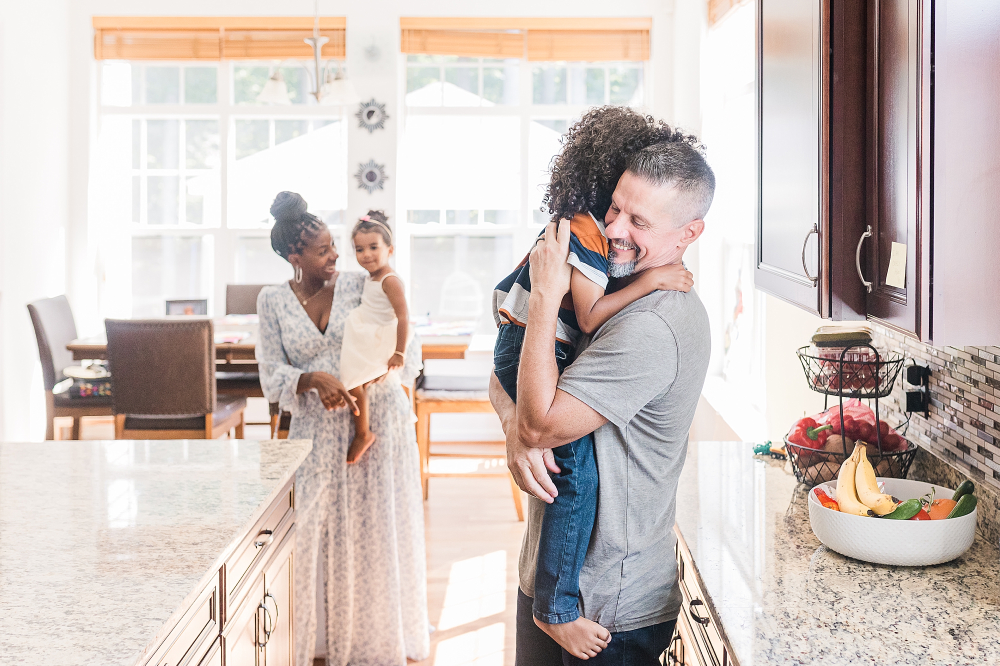 parents relax in kitchen with two daughter during Maryland family photos 