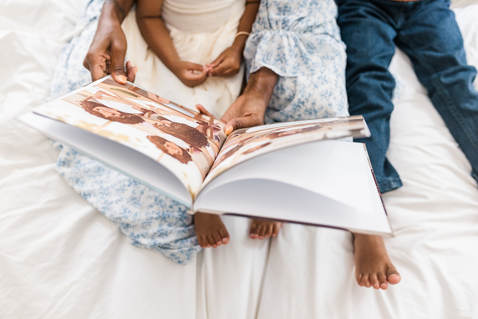 mom reads book to children during family photos on bed 