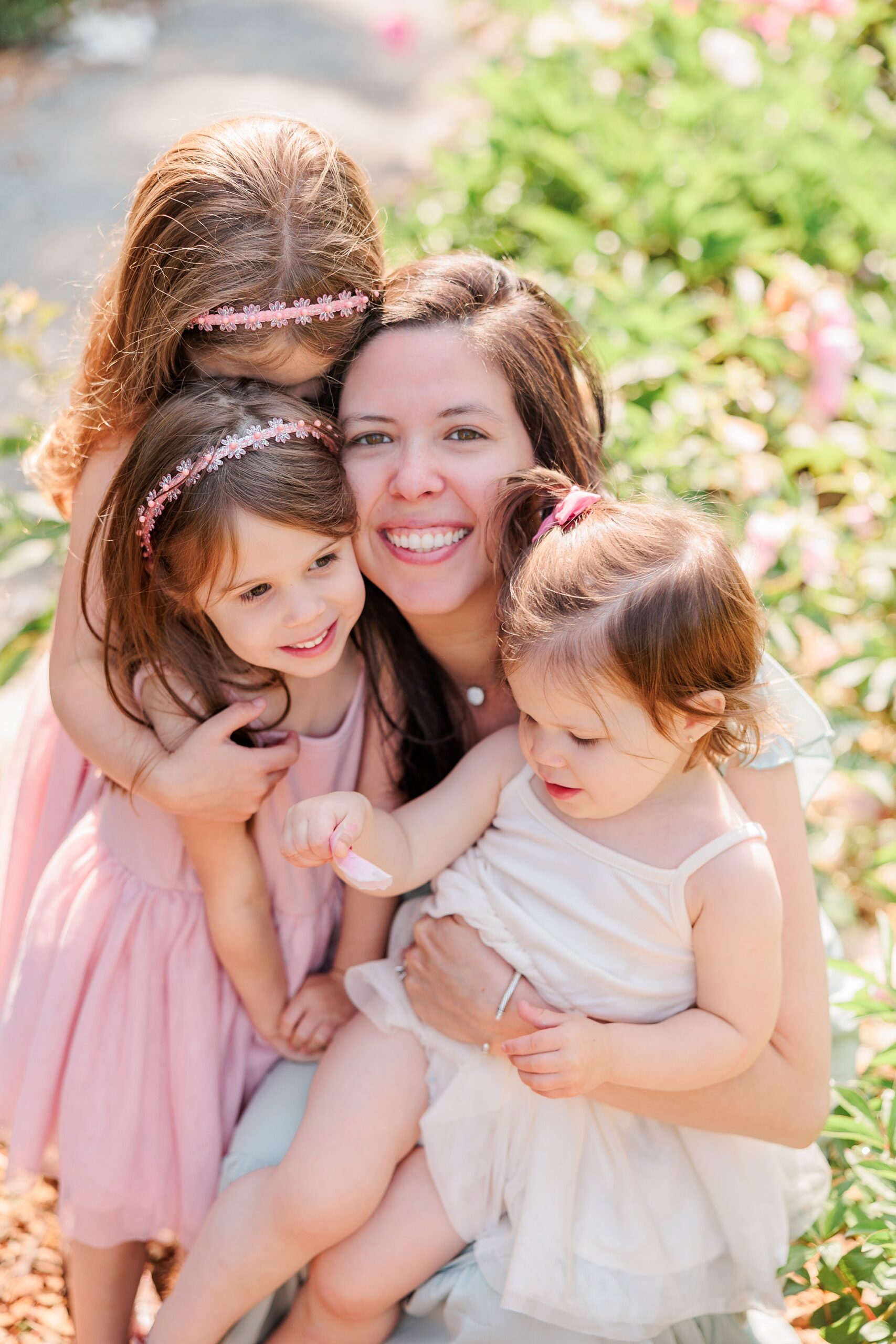 mother hugs daughters during peony mini session with Northern Virginia family photographer Christina Tundo Photography 