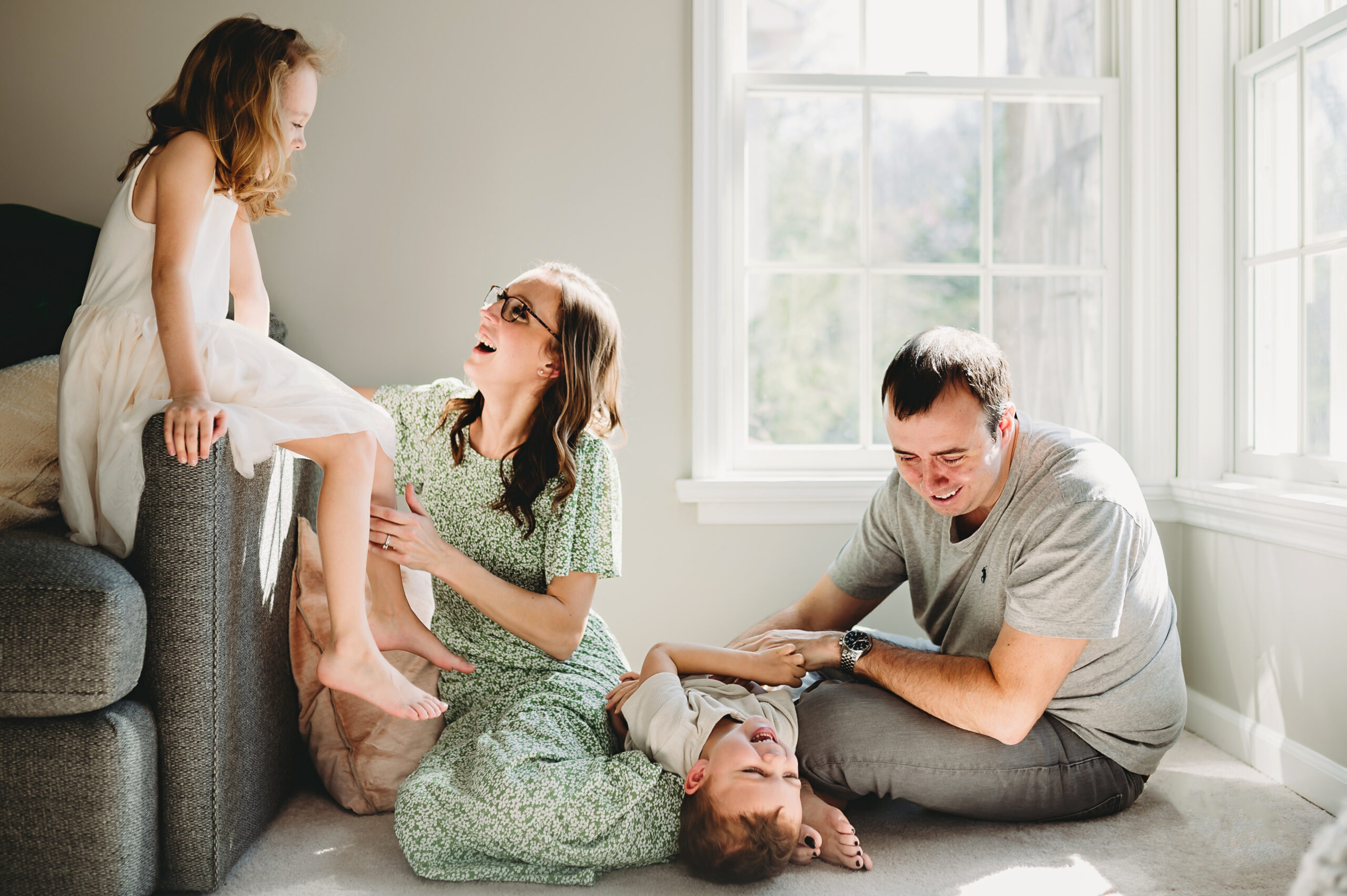 family of four laughs during in home photos in Maryland 