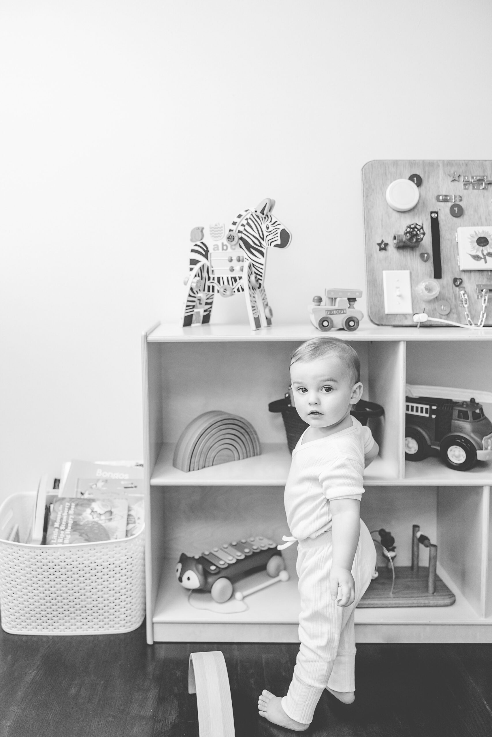 toddler reaches for toy on shelf during Maryland in-home family photos