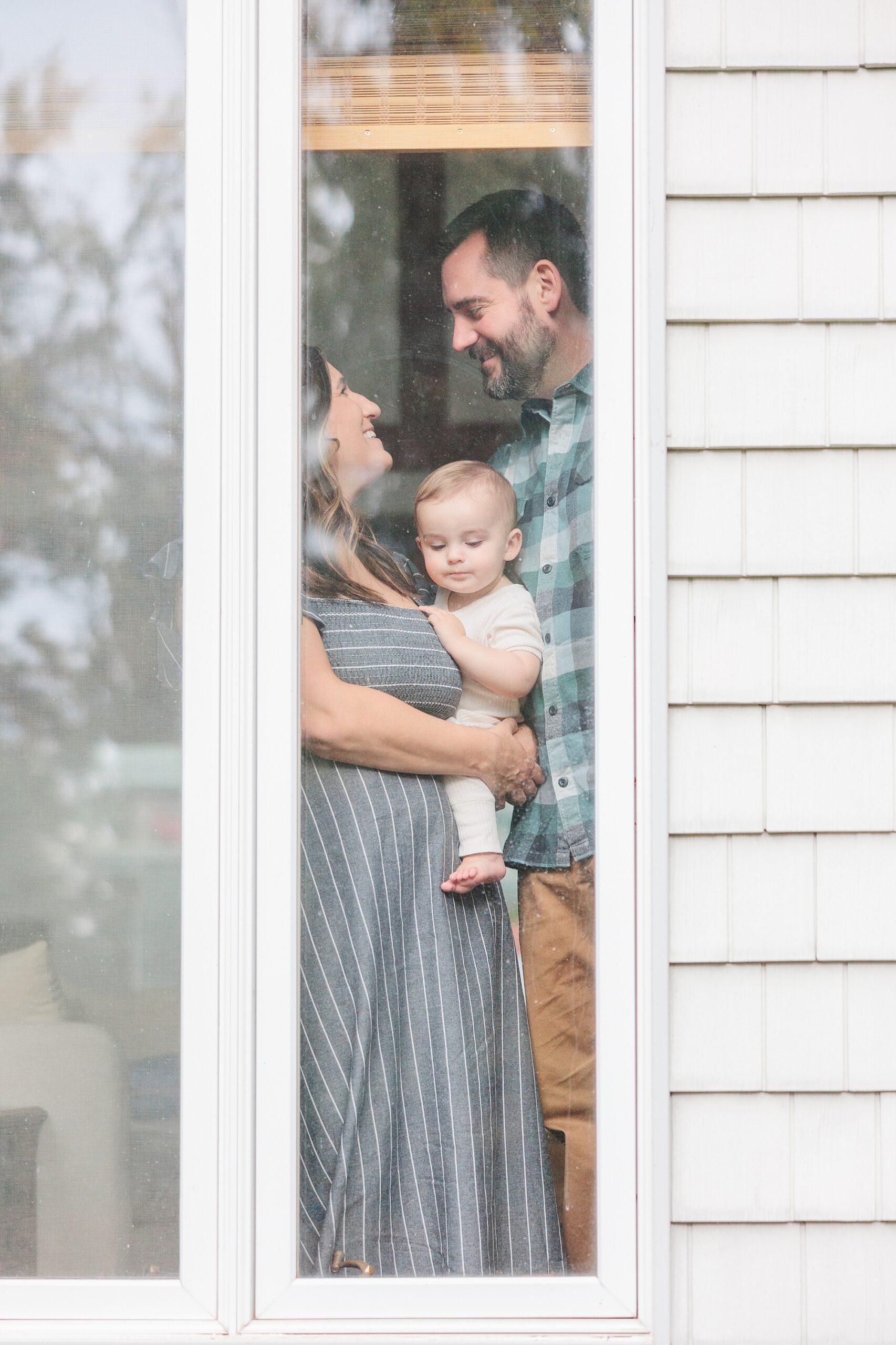 parents hug son photographed through window of Maryland home