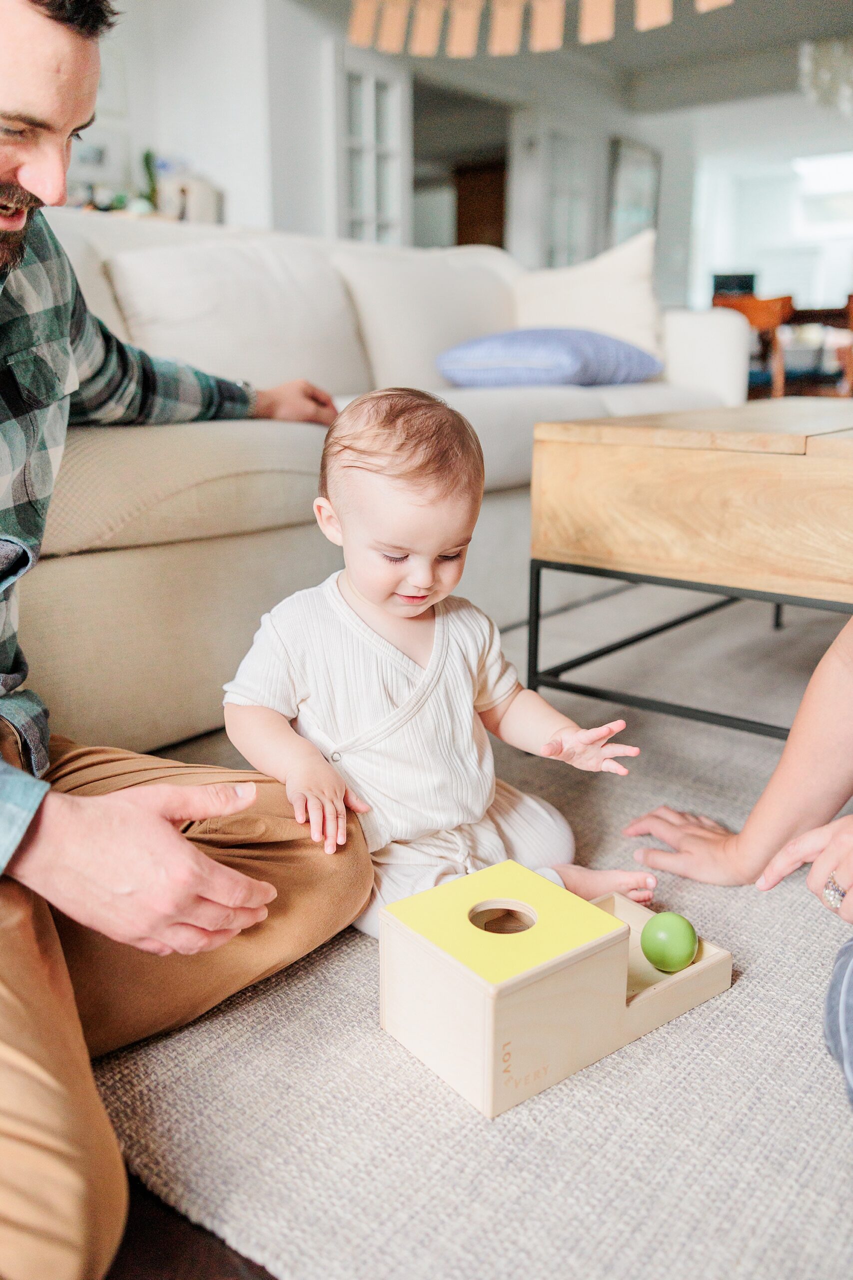 baby plays with wooden toys during in-home family photos