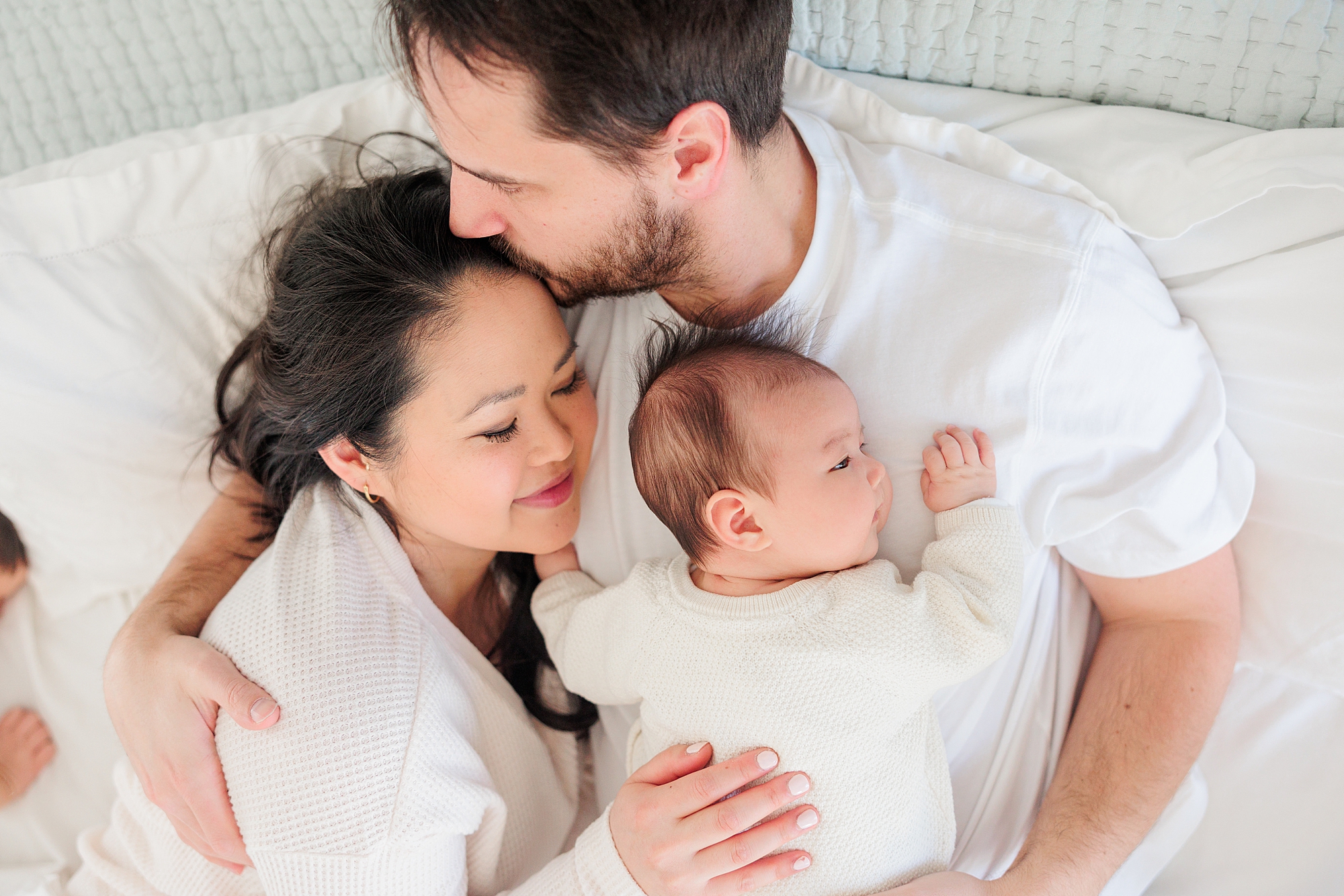 dad hugs wife and baby girl on chest during Howard County newborn and family lifestyle photos