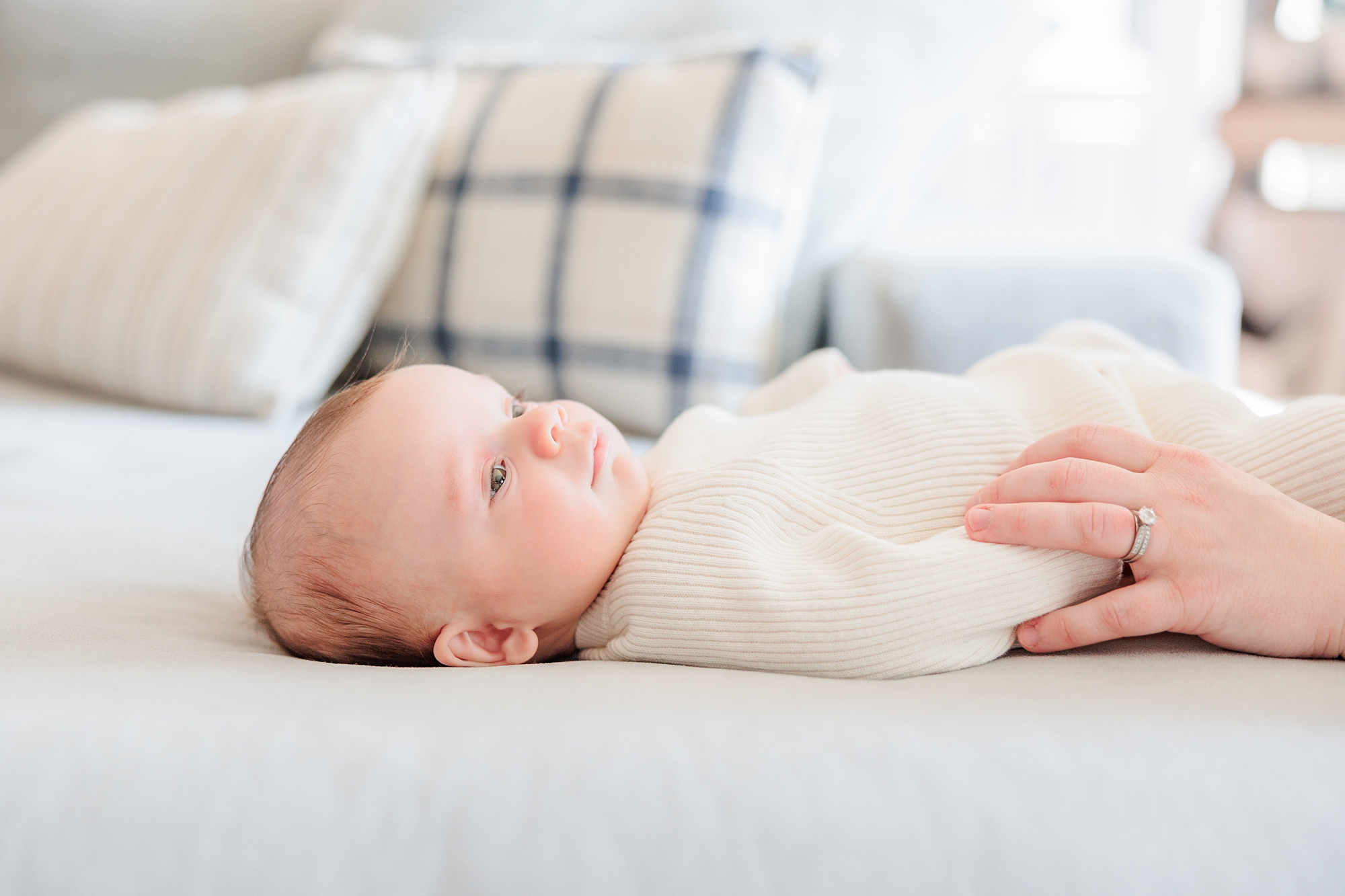 baby girl lays on couch during Maryland newborn lifestyle session