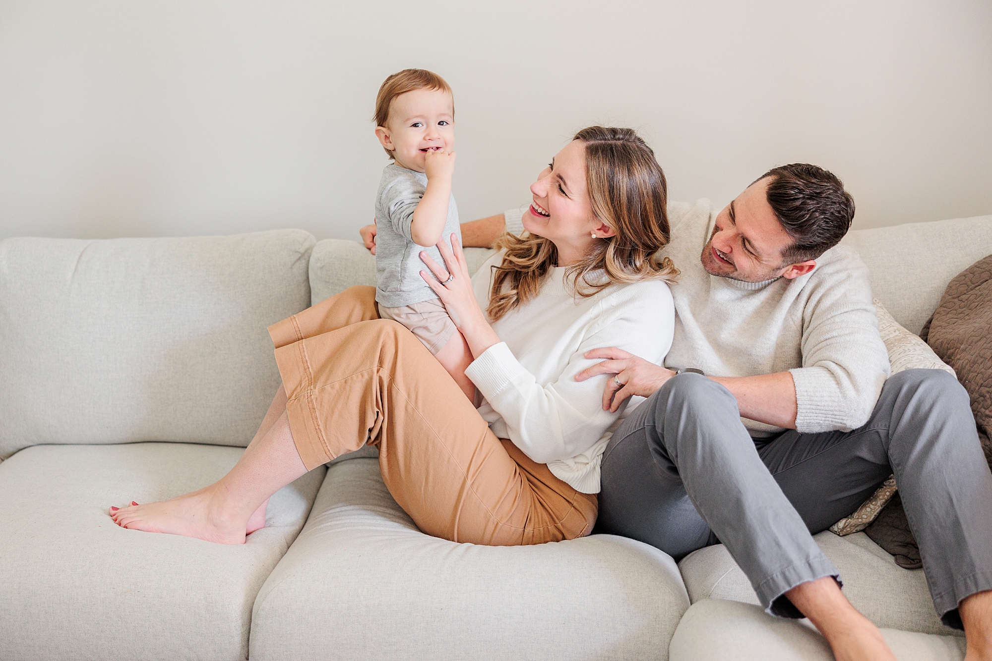 family of three sits on couch during Maryland lifestyle family photos 