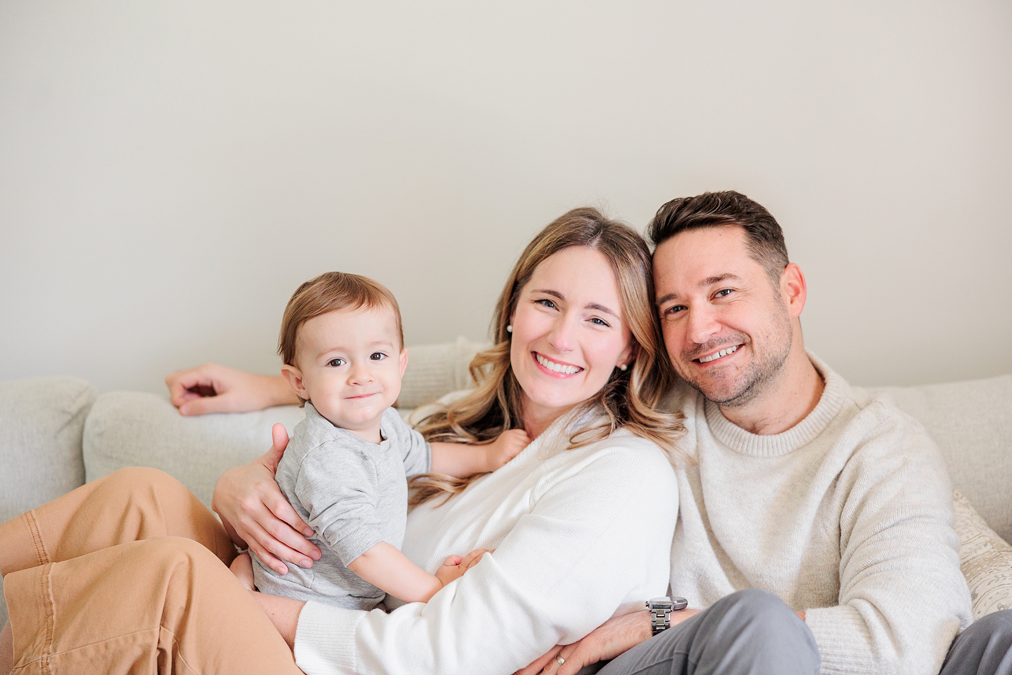parents snuggle with son during family photos at home 