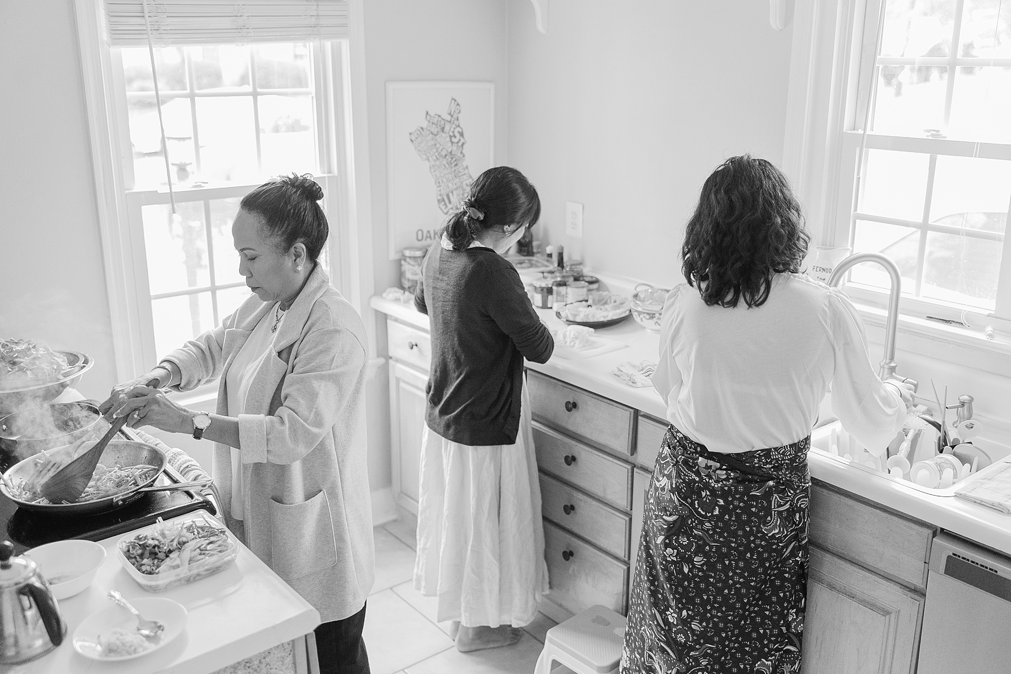 three women work in kitchen during lifestyle family photos in Northern VA