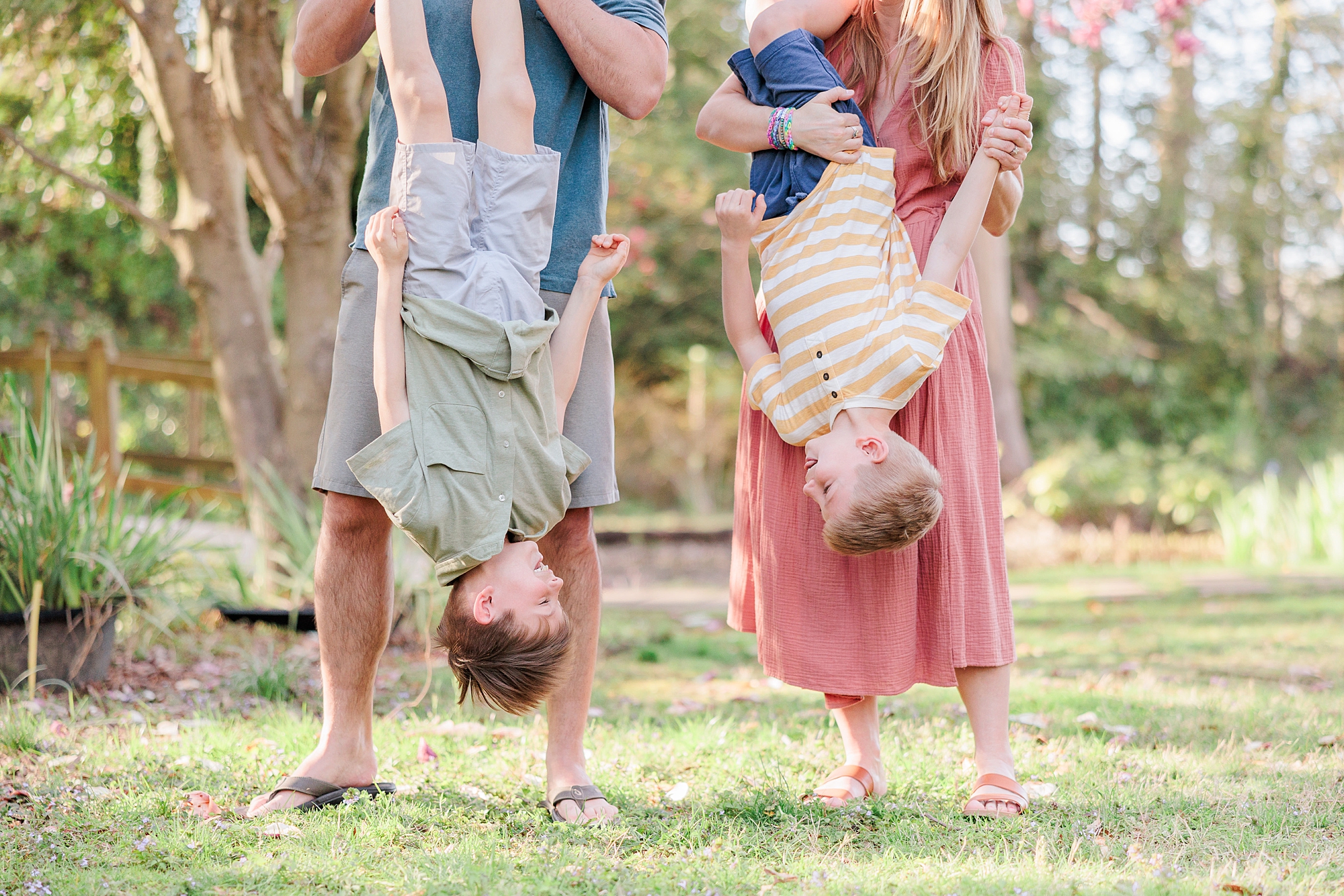 parents hold sons upside down during outdoor family photos in DC