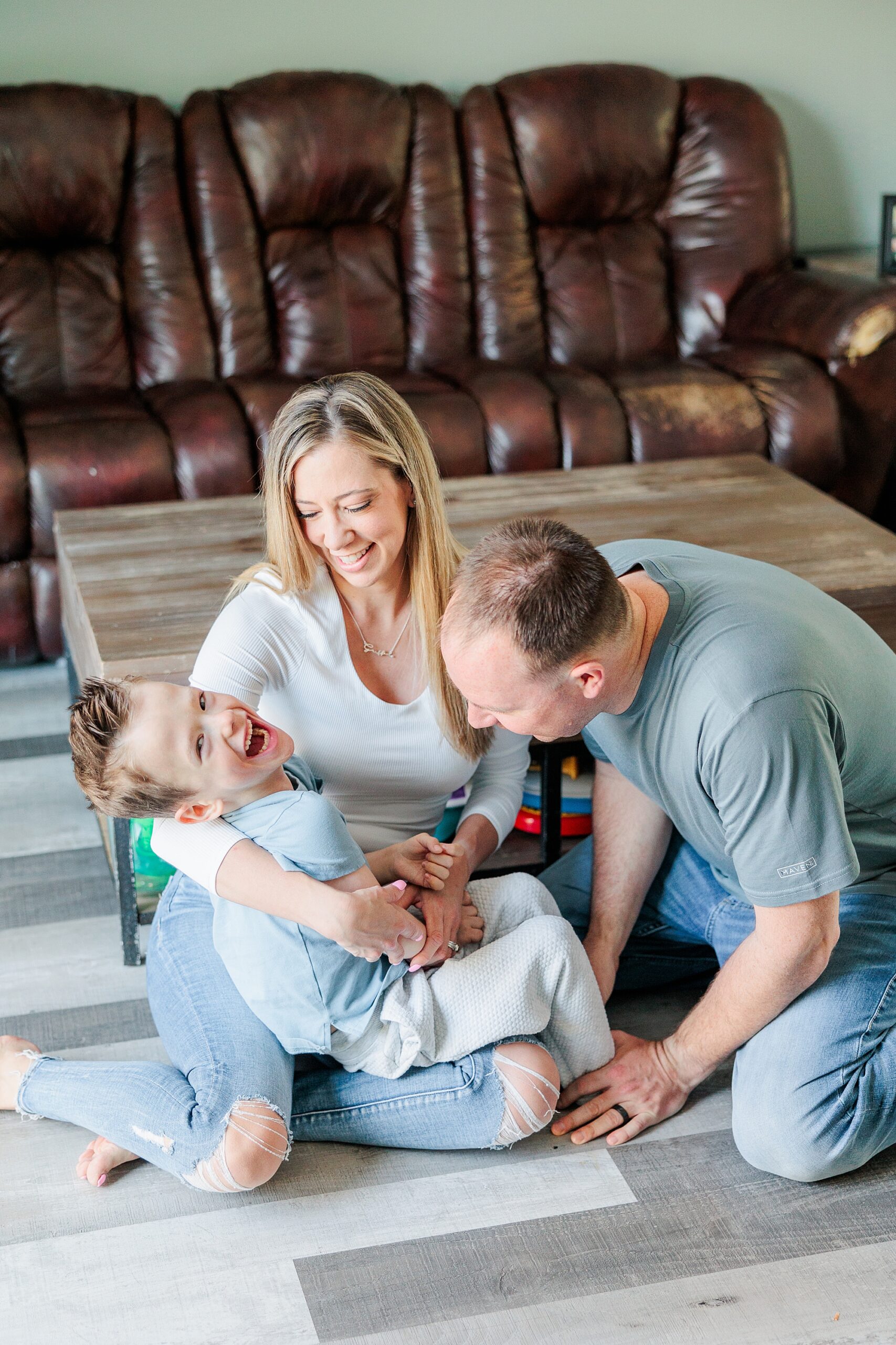 parents play with son with special needs on floor of home