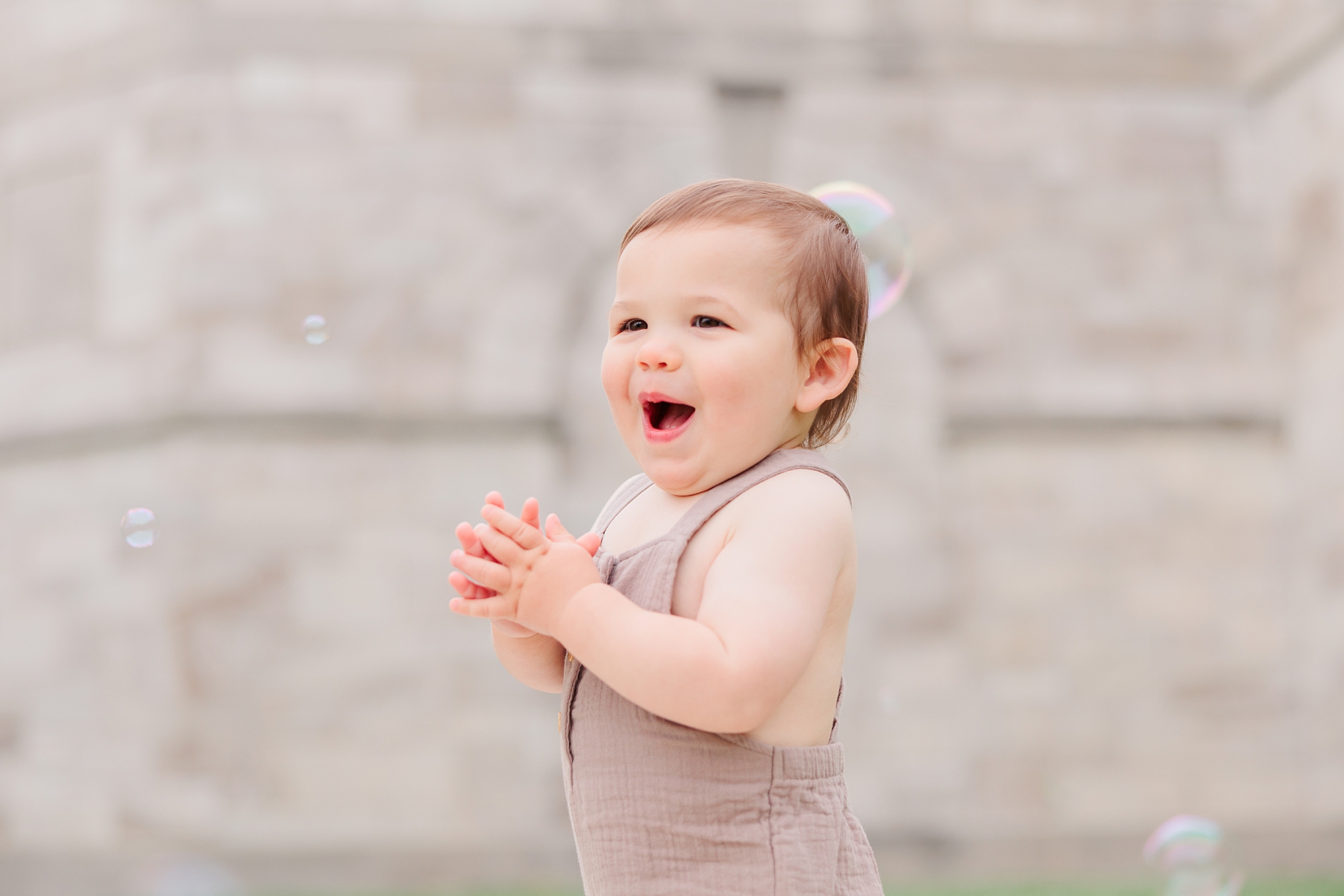 baby in brown onesie claps at bubbles during Maryland Family Session in Ellicott City 