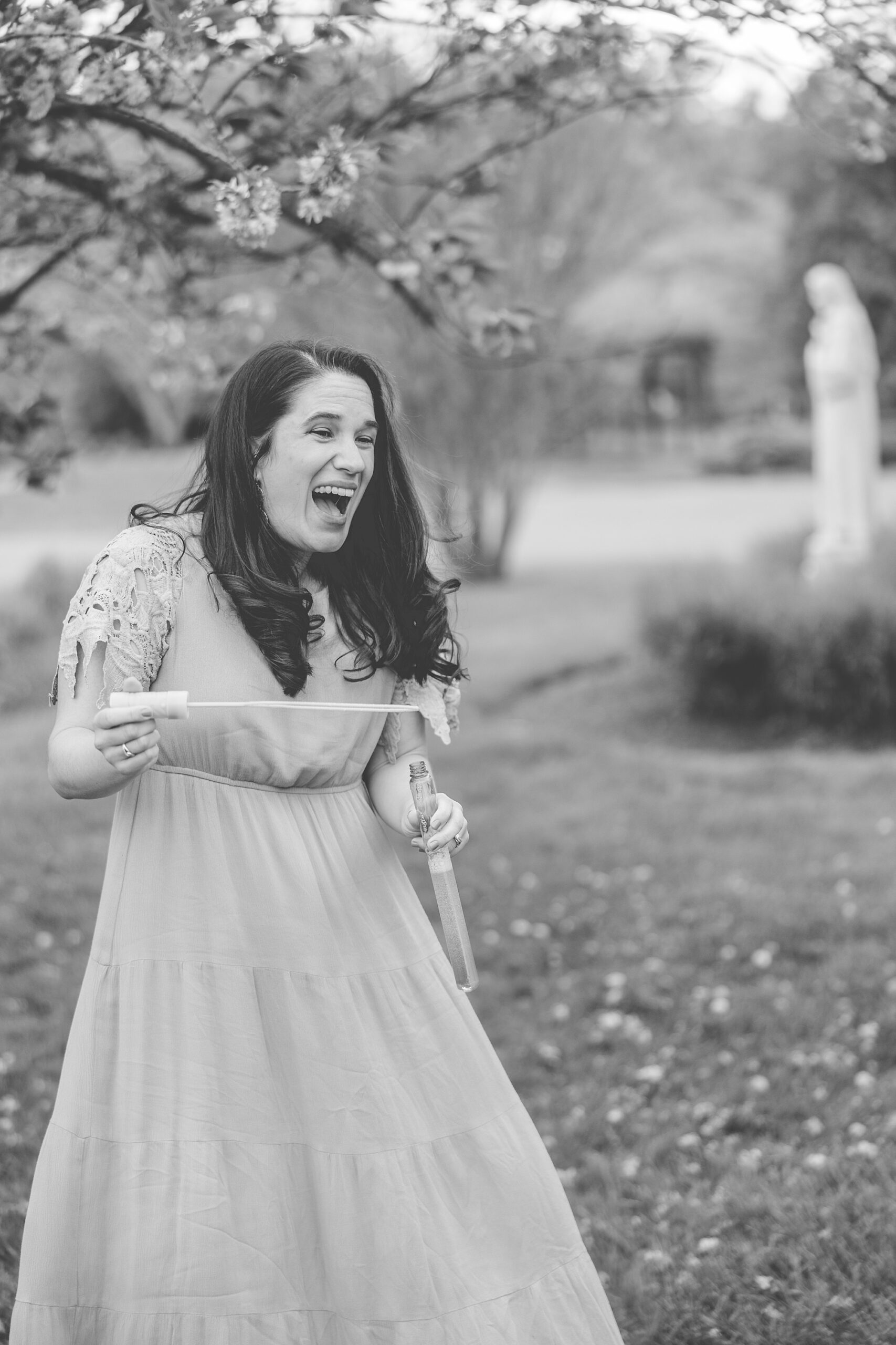 woman laughs blowing bubbles for son during Maryland Family Session in Ellicott City 