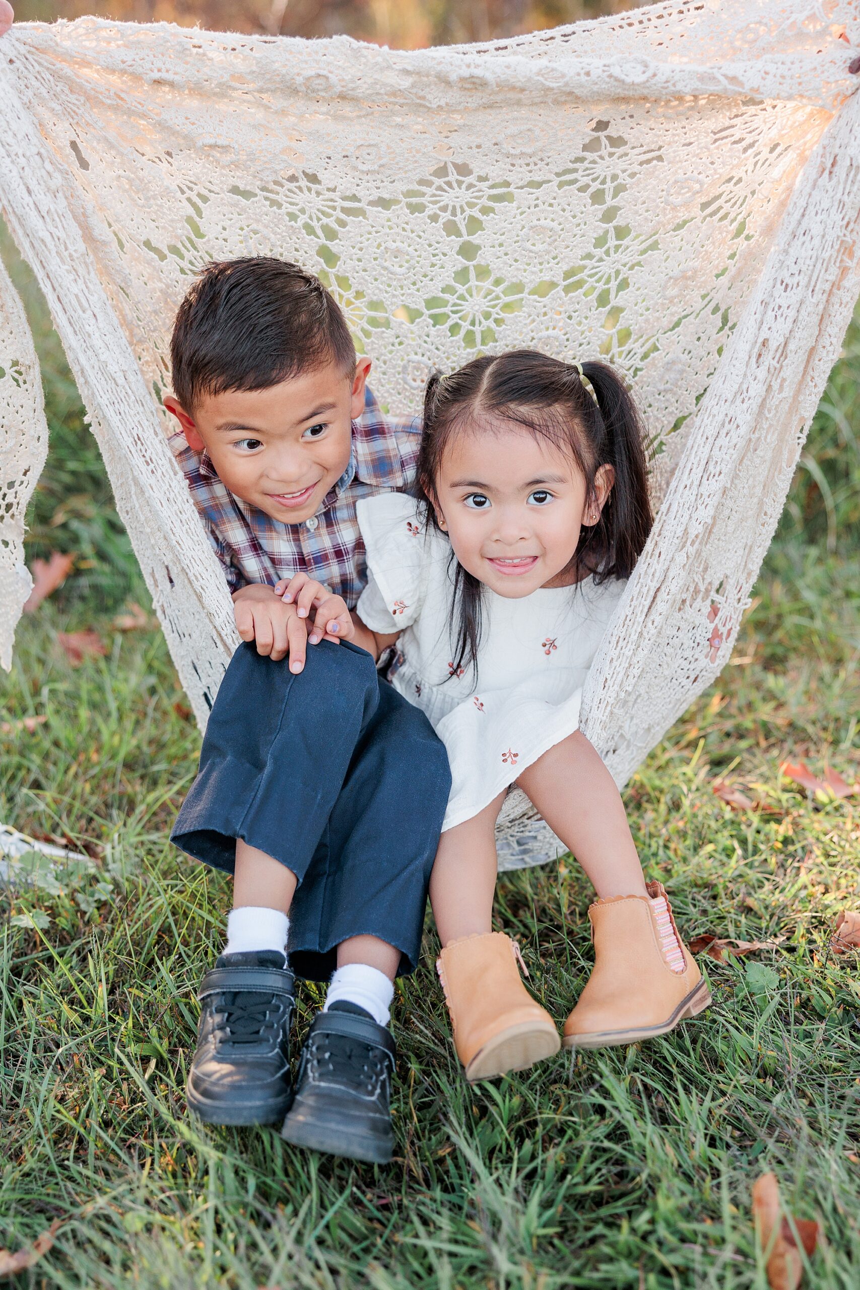 two kids sit in knit blanket during fall family photos