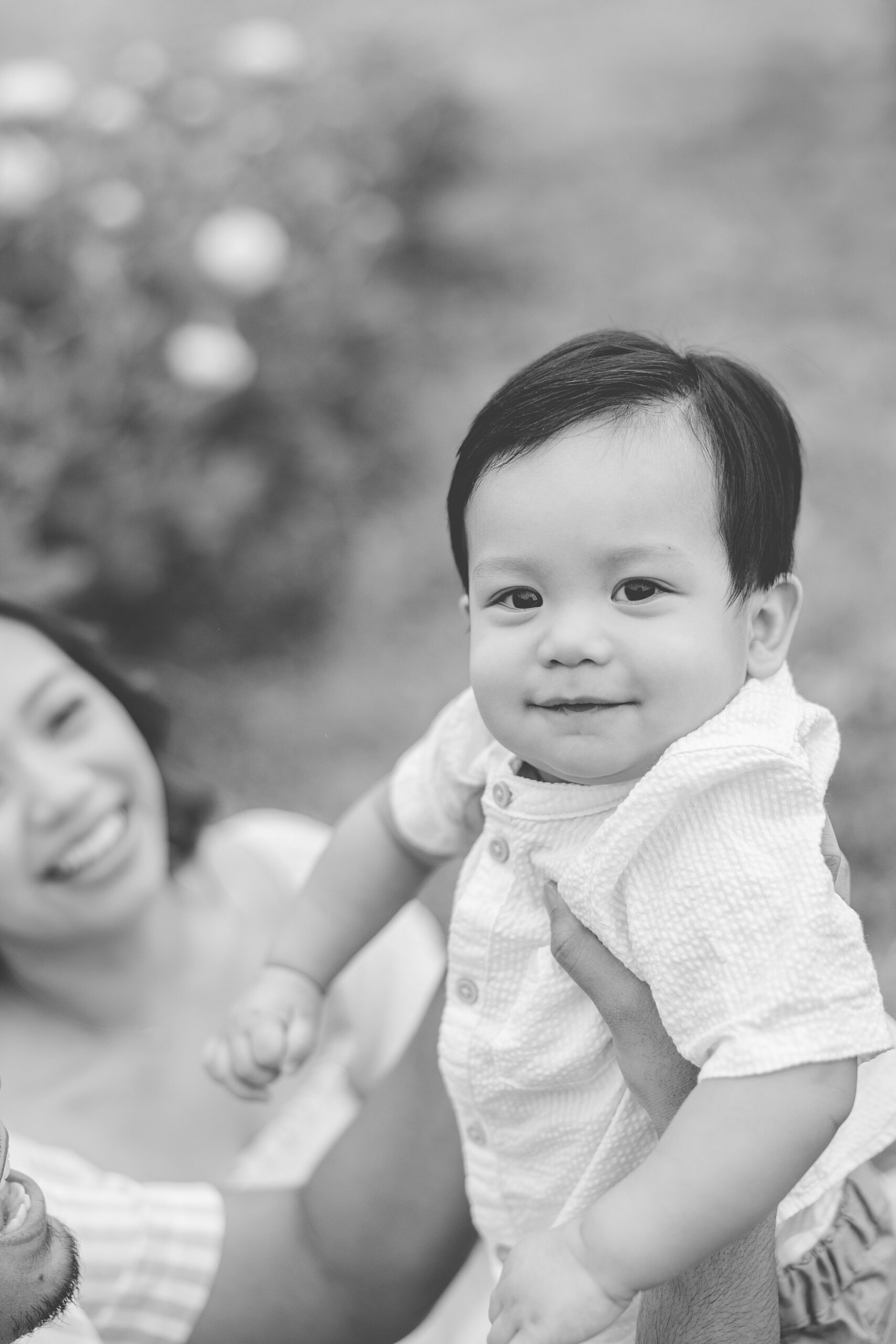 black and white photo of mom holding up son and smiling at him