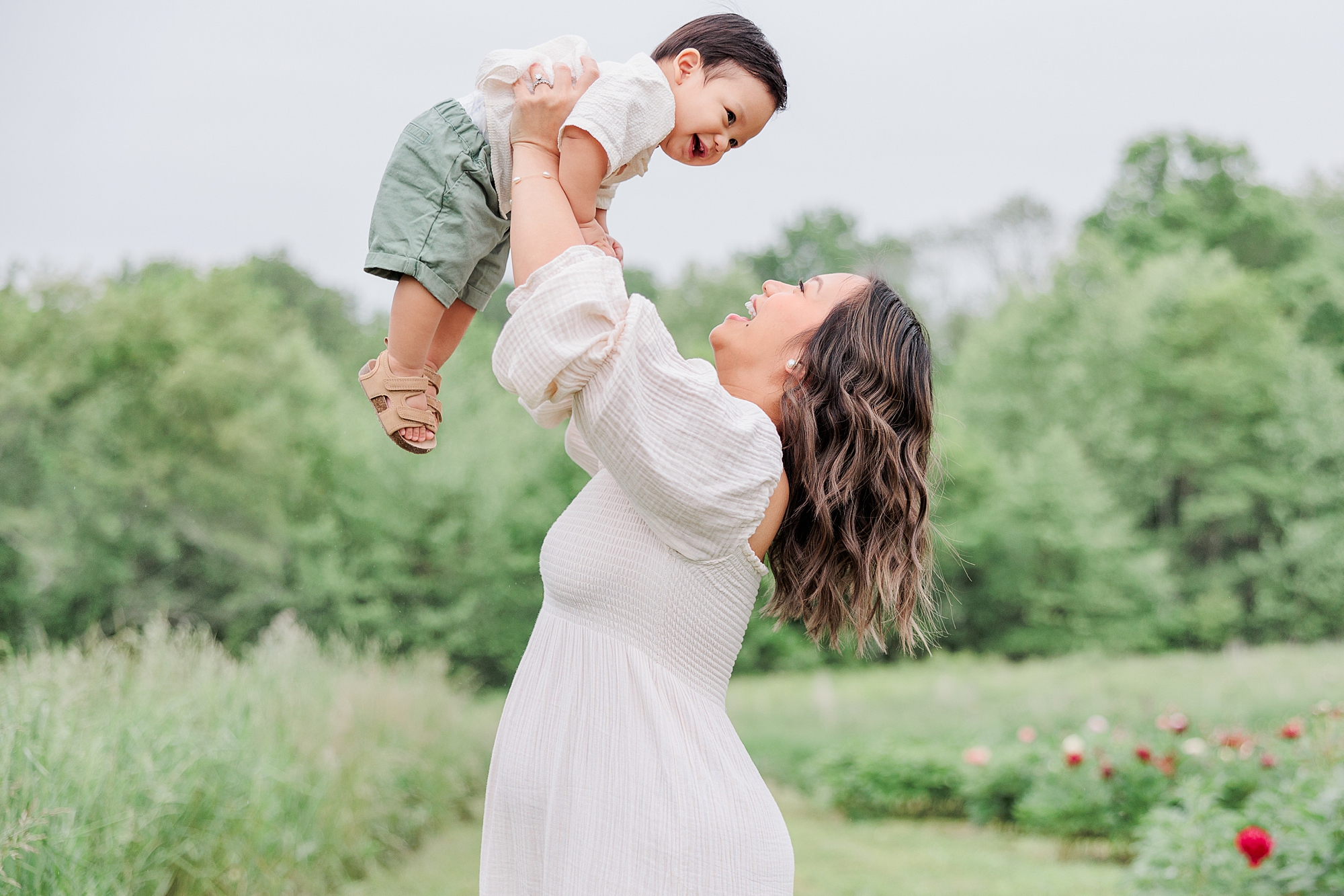 mom lifts up son in the air during family photos at Castlebridge Farm