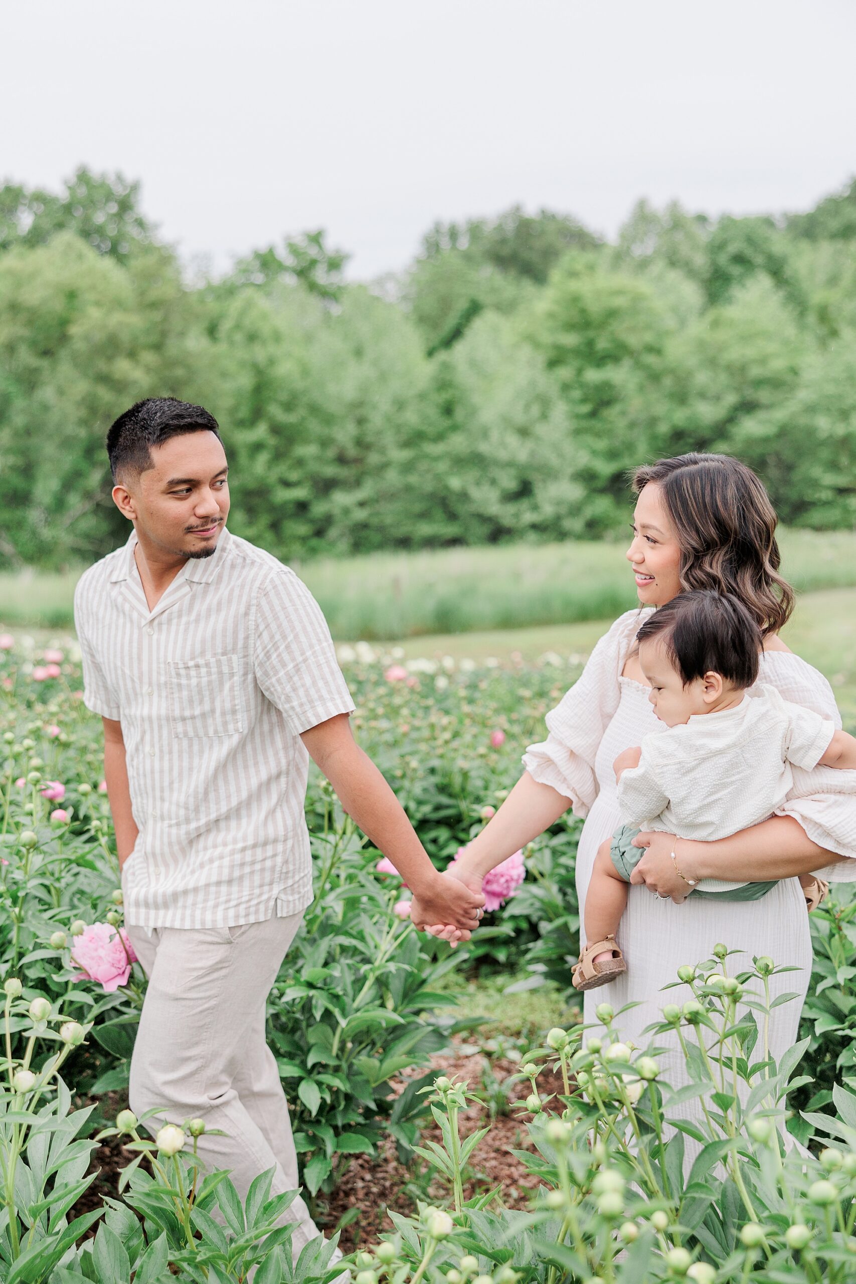 man looks back at wife carrying their son during family photos