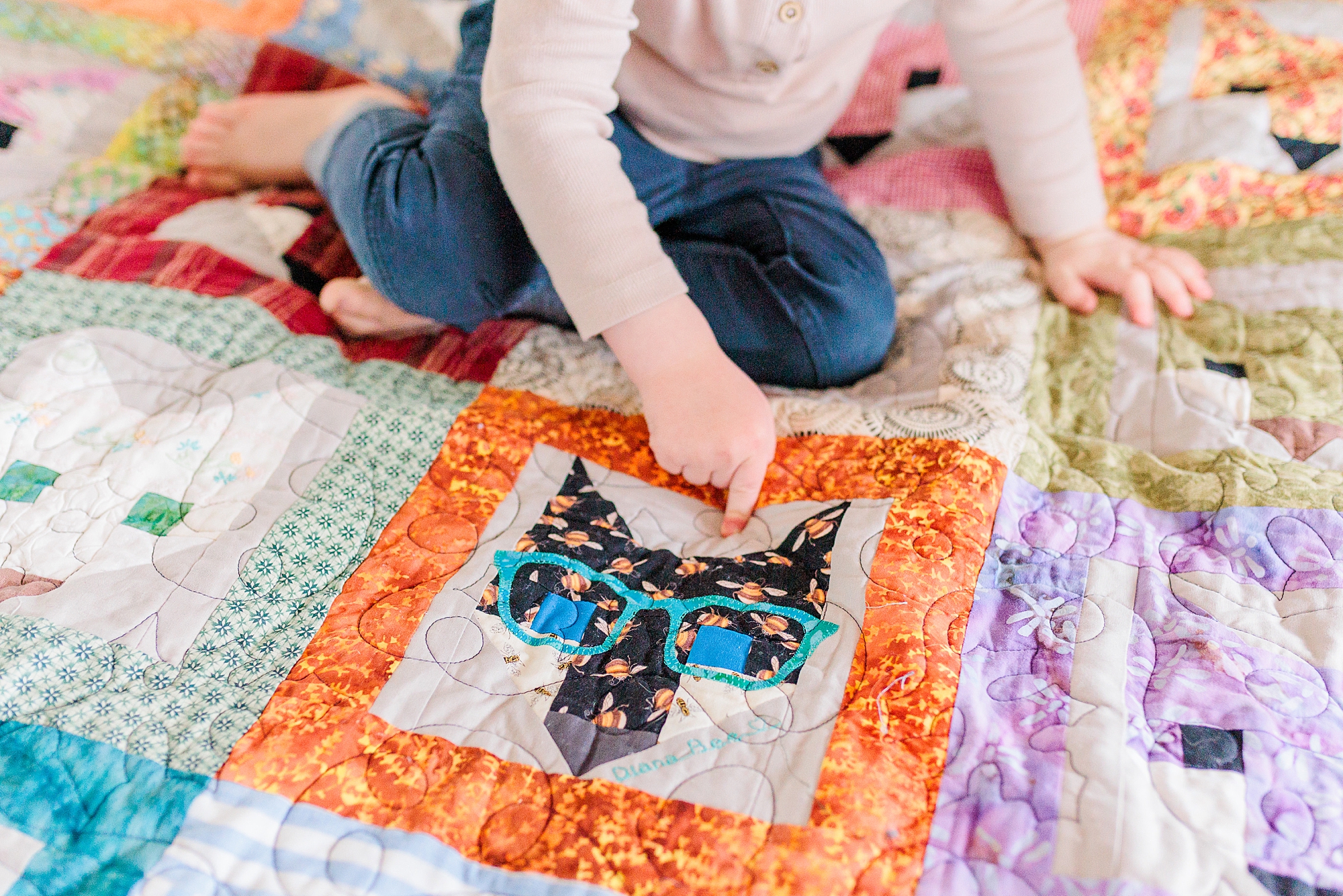 toddler sits on blanket playing with yarn