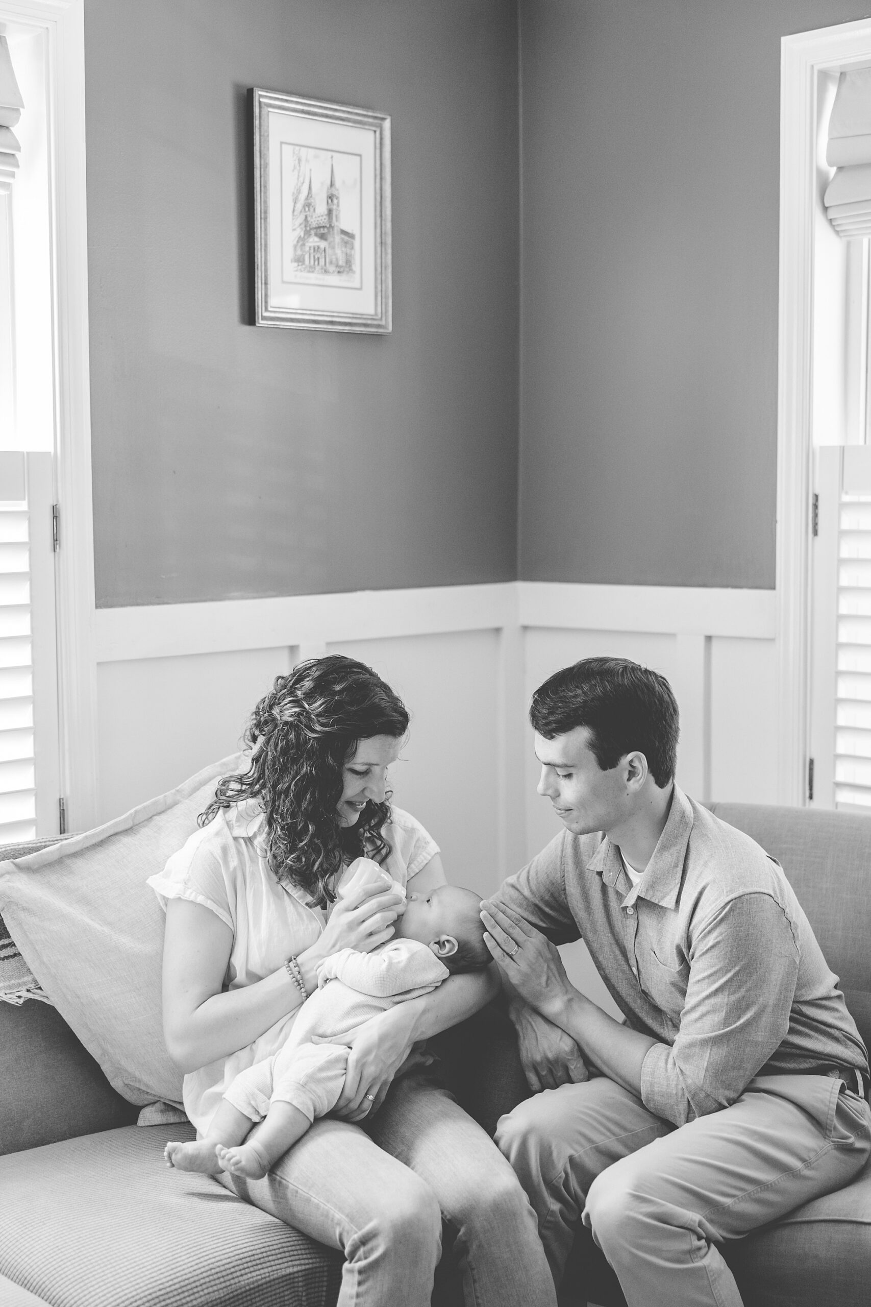 new parents look at son during newborn lifestyle photography session at home 