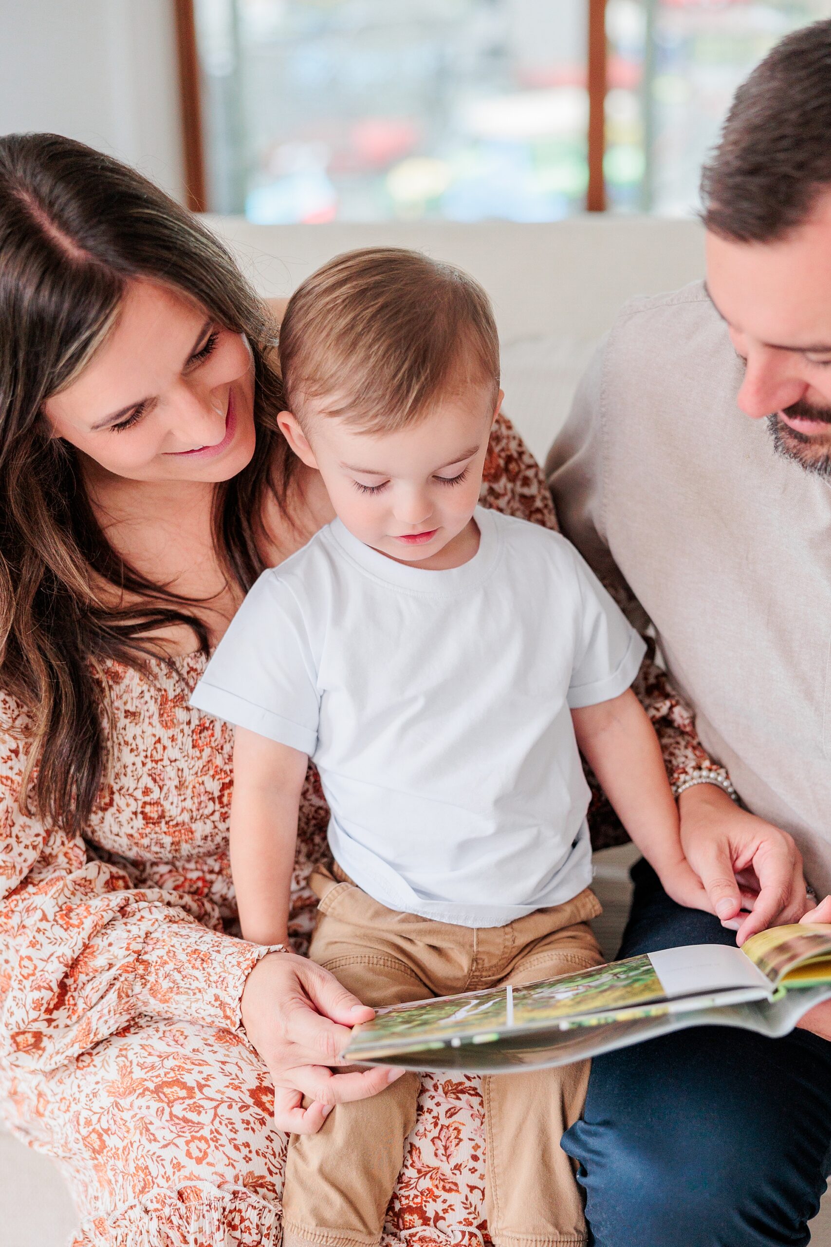 parents read with young son during family photos at home in Columbia MD