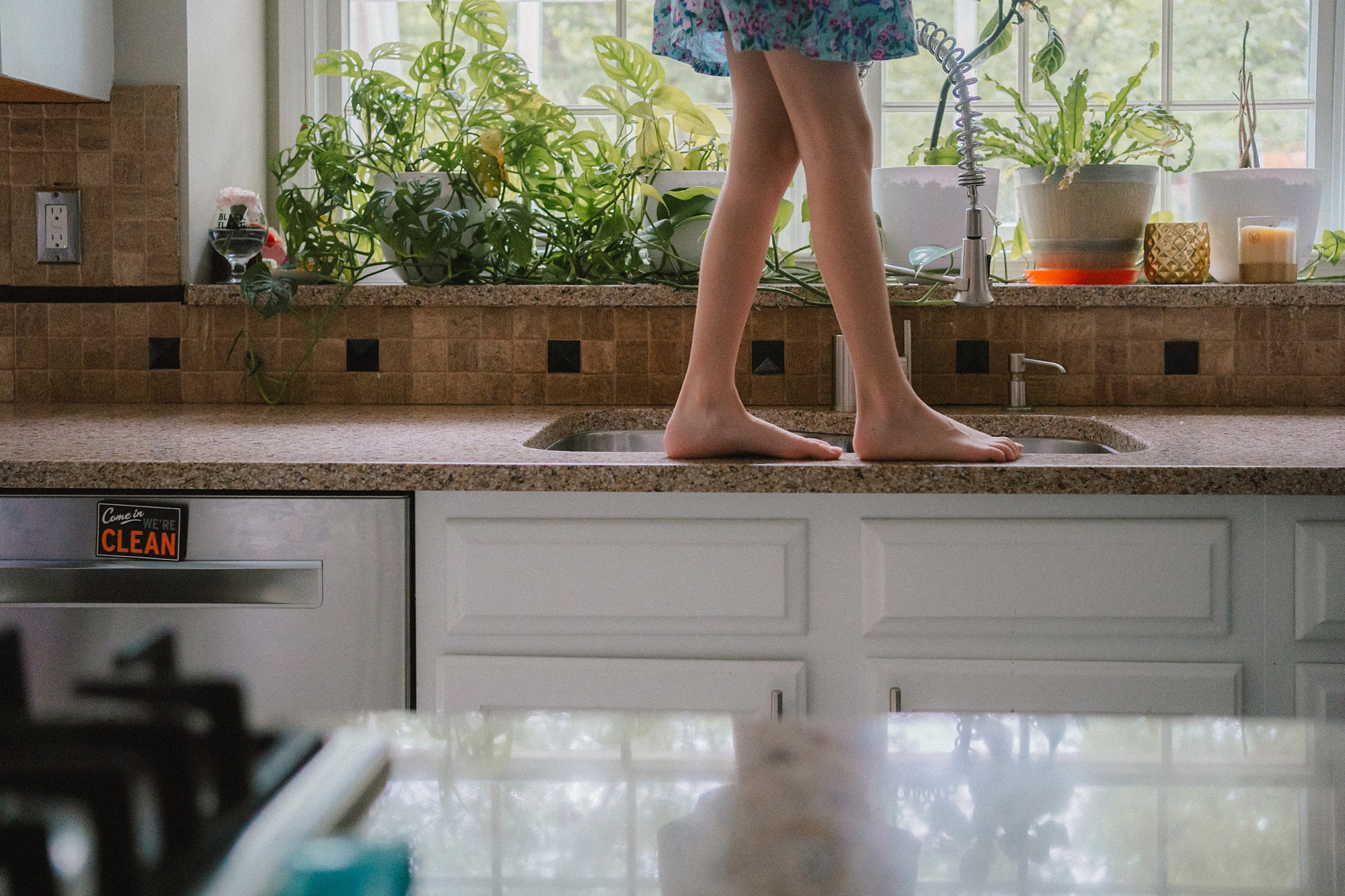 girl walks along kitchen sink in Maryland home 